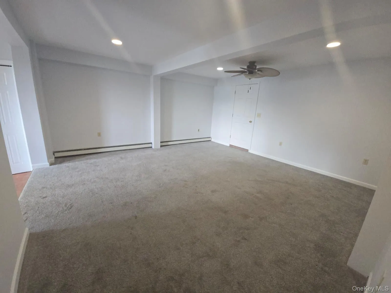 Spare room featuring ceiling fan, light colored carpet, recessed lighting, and a baseboard radiator Spare room featuring ceiling fan, light colored carpet, recessed lighting, and a baseboard radiator