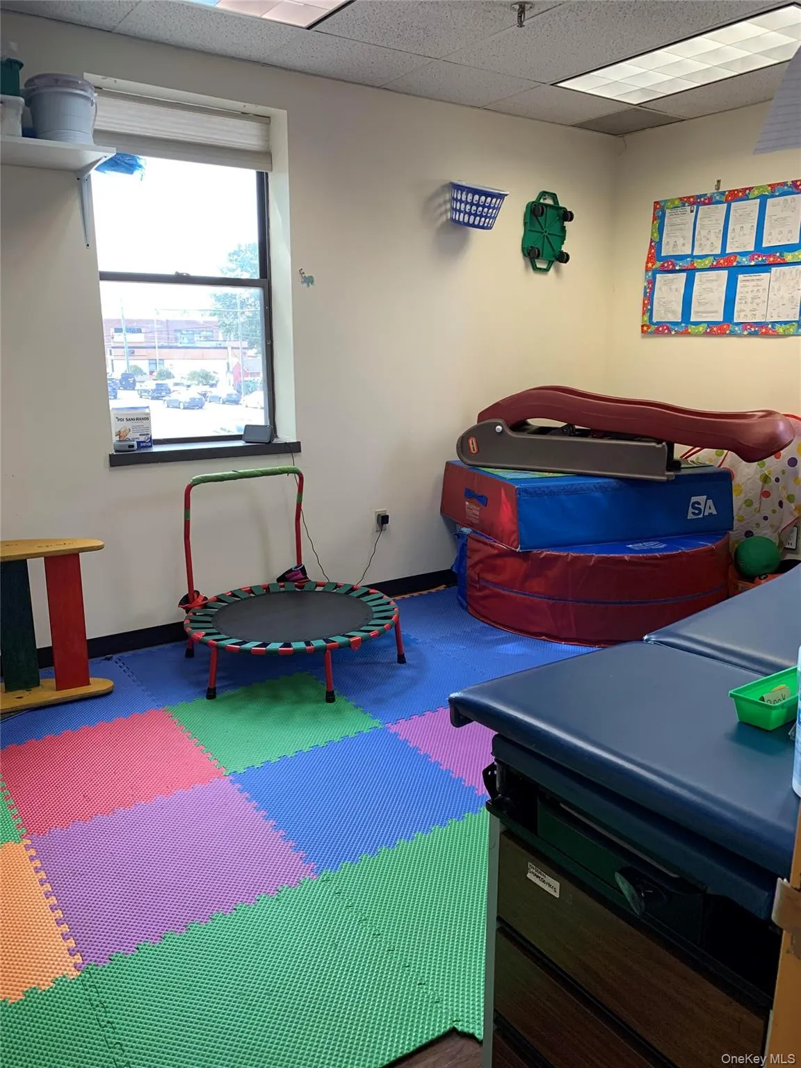 Playroom with a paneled ceiling and baseboards Playroom with a paneled ceiling and baseboards