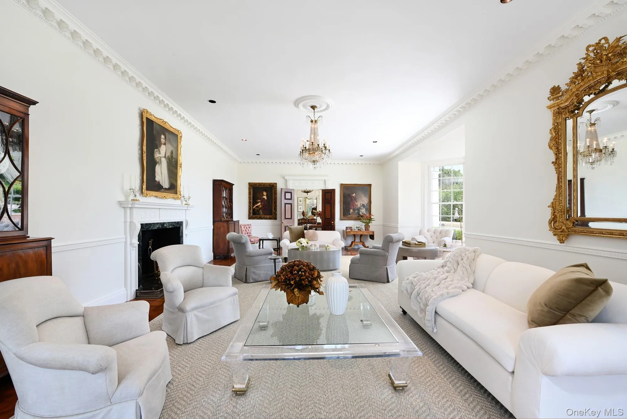 Living area with ornamental molding, a chandelier, a high end fireplace, and wood finished floors Living area with ornamental molding, a chandelier, a high end fireplace, and wood finished floors
