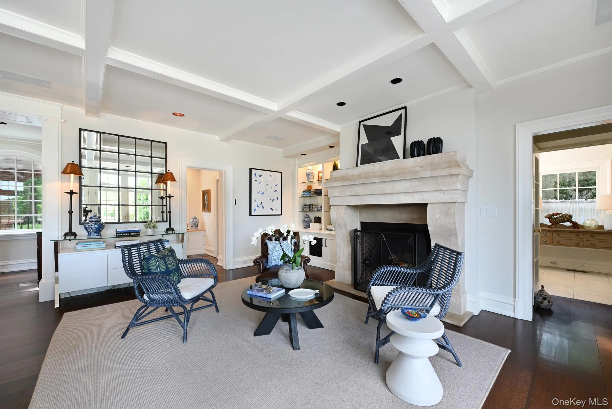 Living area with dark wood-type flooring, beamed ceiling, coffered ceiling, and a high end fireplace Living area with dark wood-type flooring, beamed ceiling, coffered ceiling, and a high end fireplace