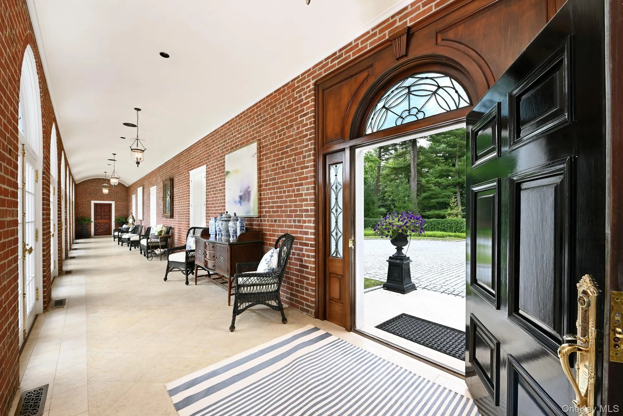 Entrance foyer featuring brick wall Entrance foyer featuring brick wall