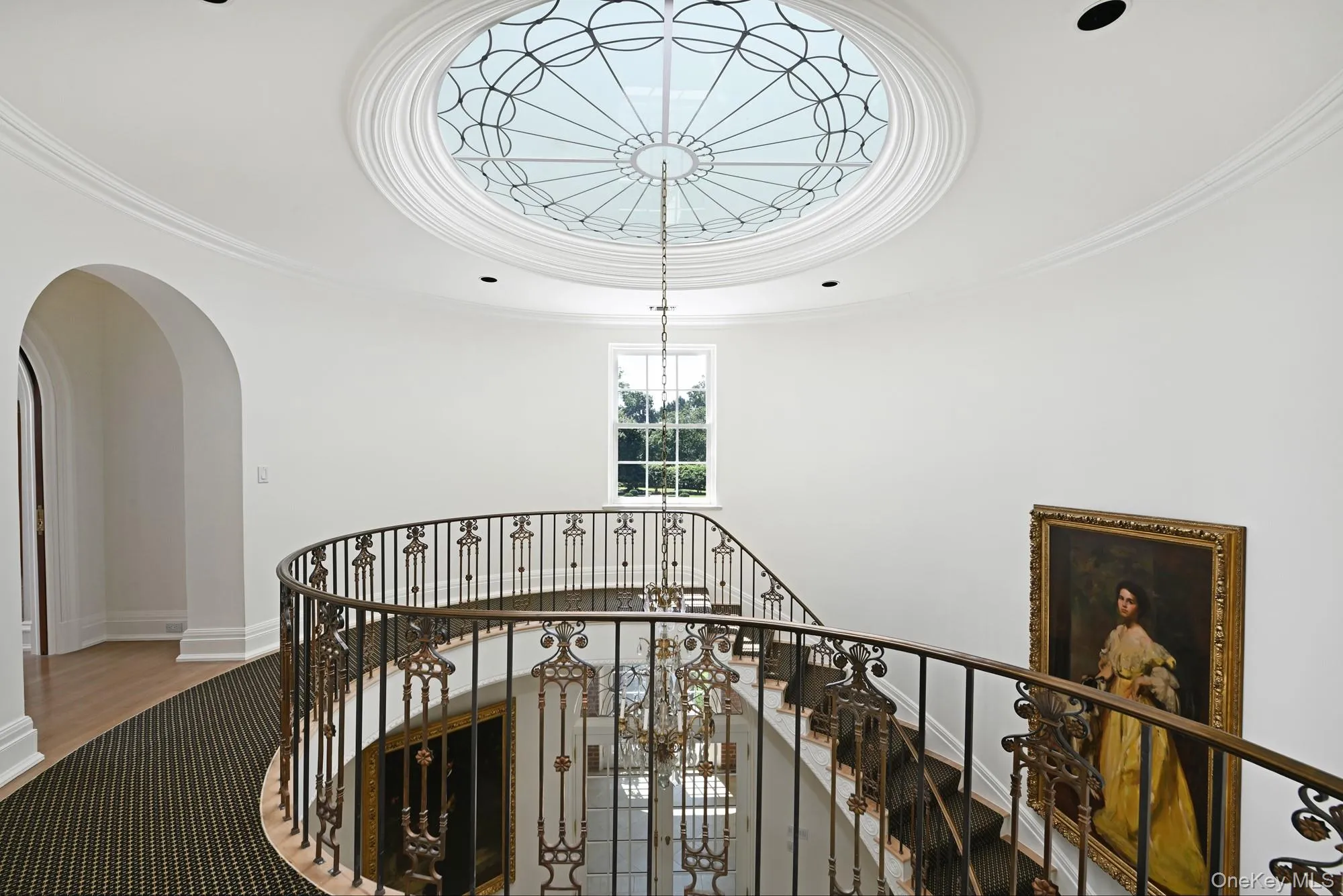 Stairs featuring crown molding, a chandelier, and arched walkways Stairs featuring crown molding, a chandelier, and arched walkways