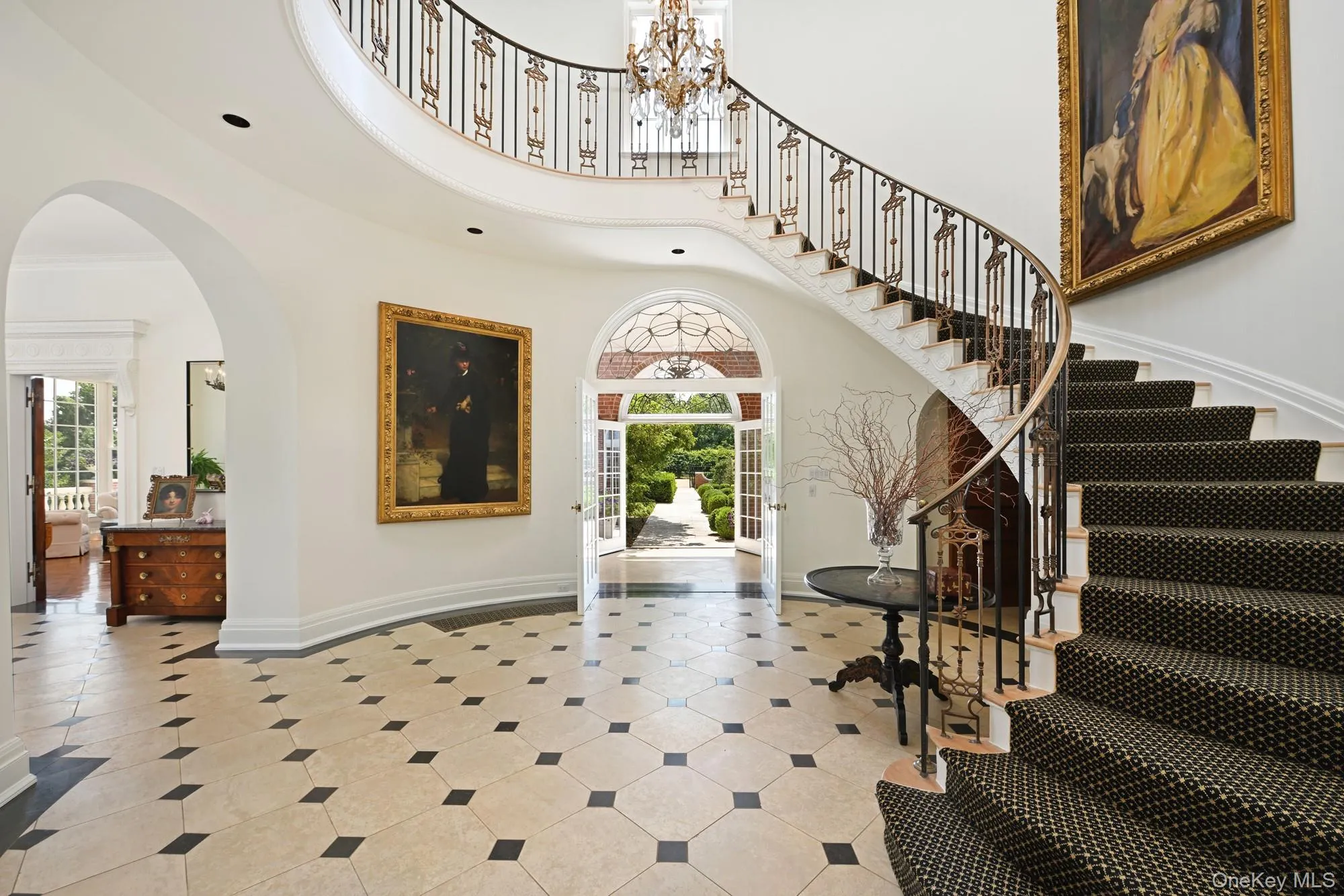 Entrance foyer featuring a chandelier, arched walkways, a towering ceiling, french doors, and stairway Entrance foyer featuring a chandelier, arched walkways, a towering ceiling, french doors, and stairway