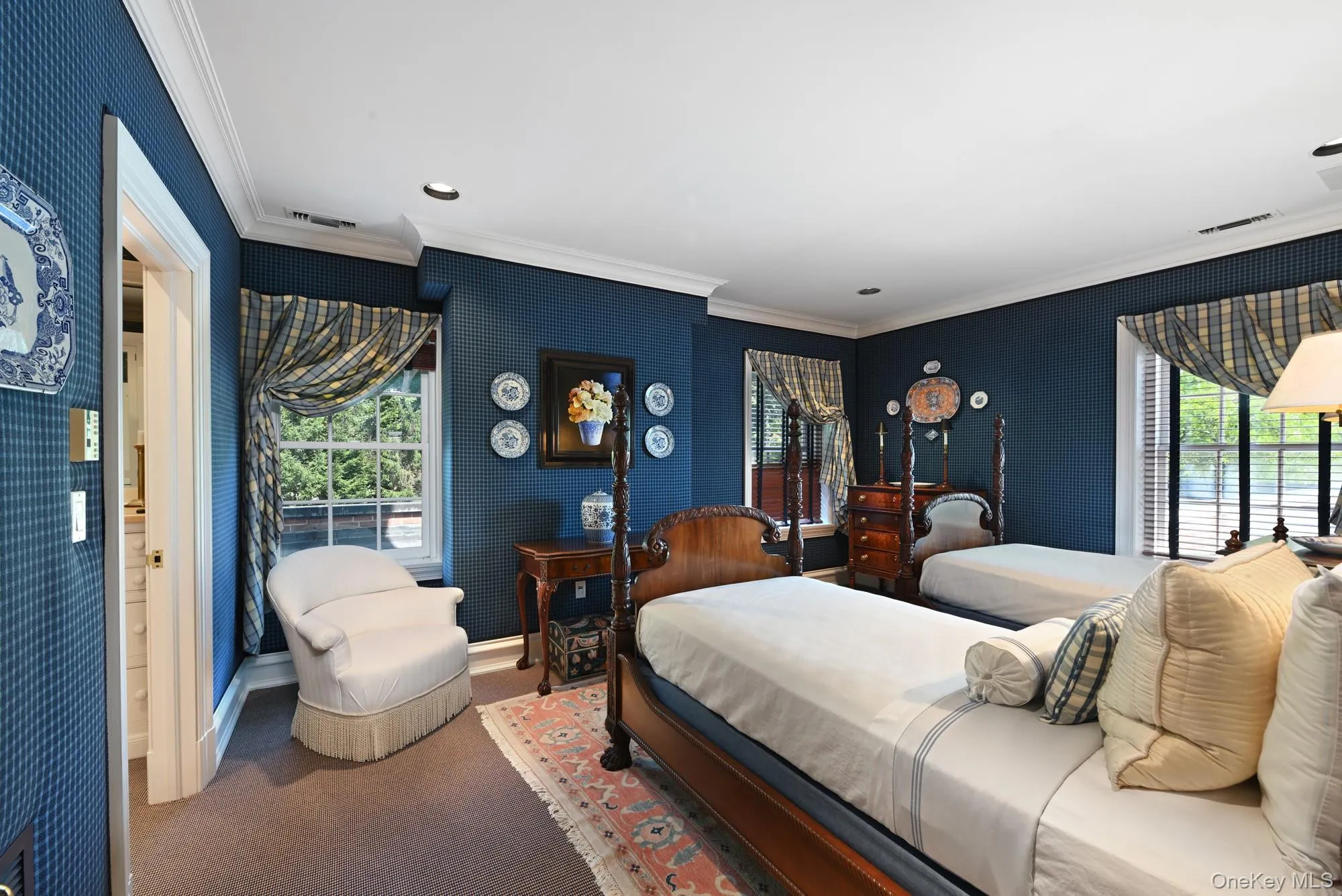 Carpeted bedroom with crown molding, wallpapered walls, multiple windows, and recessed lighting Carpeted bedroom with crown molding, wallpapered walls, multiple windows, and recessed lighting
