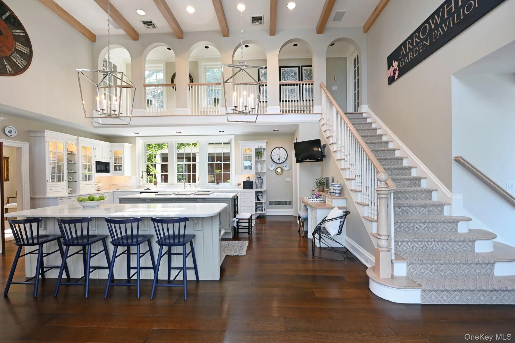 Kitchen with white cabinets, recessed lighting, a center island, glass insert cabinets, and a breakfast bar area Kitchen with white cabinets, recessed lighting, a center island, glass insert cabinets, and a breakfast bar area
