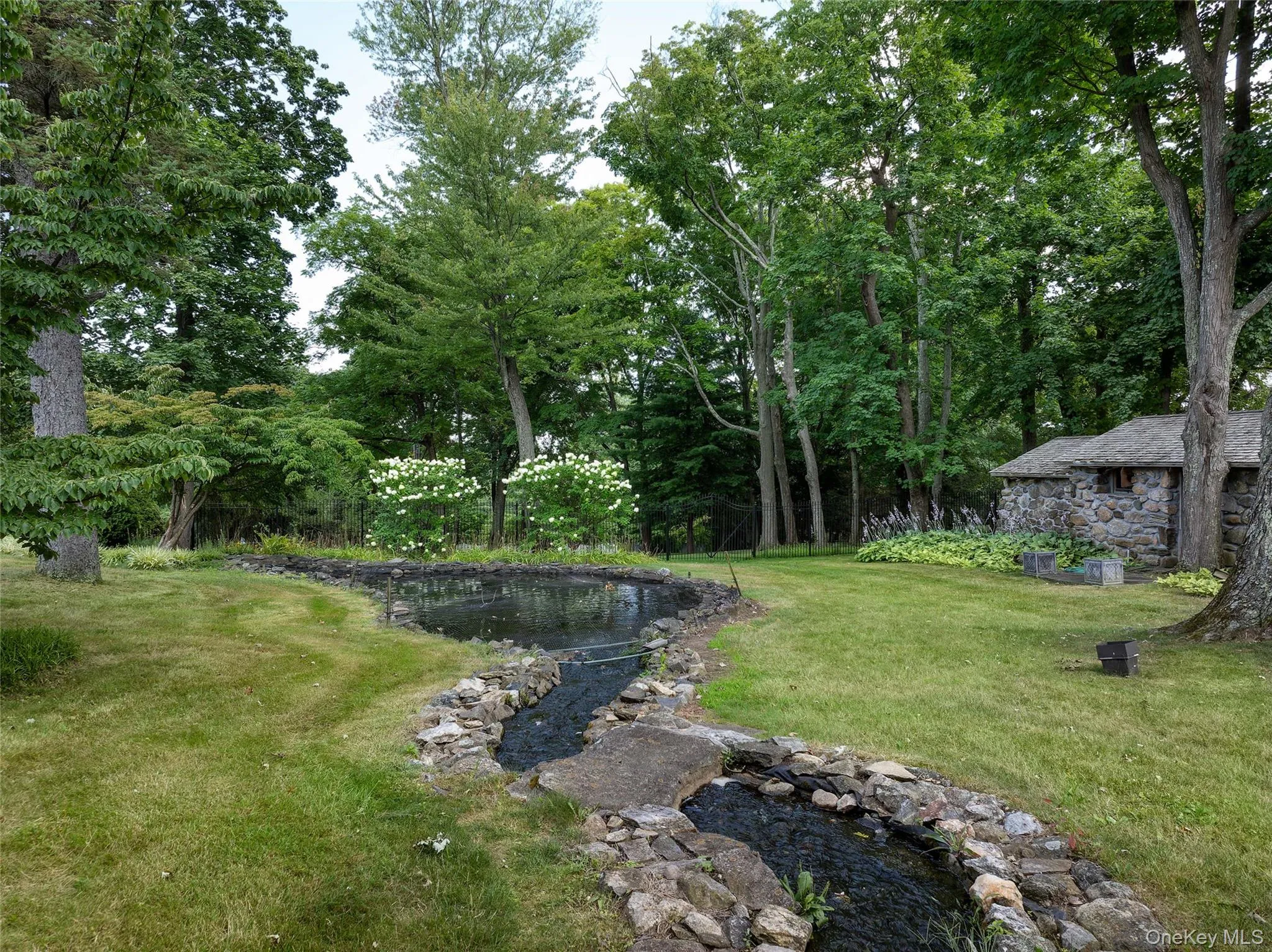 View of grassy yard with a garden pond View of grassy yard with a garden pond