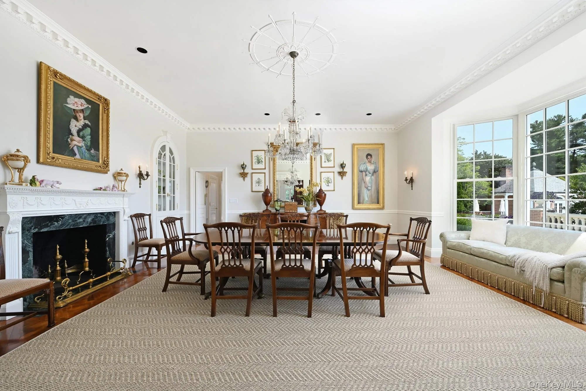 Dining room featuring ornamental molding, a fireplace, dark wood-type flooring, and a chandelier Dining room featuring ornamental molding, a fireplace, dark wood-type flooring, and a chandelier