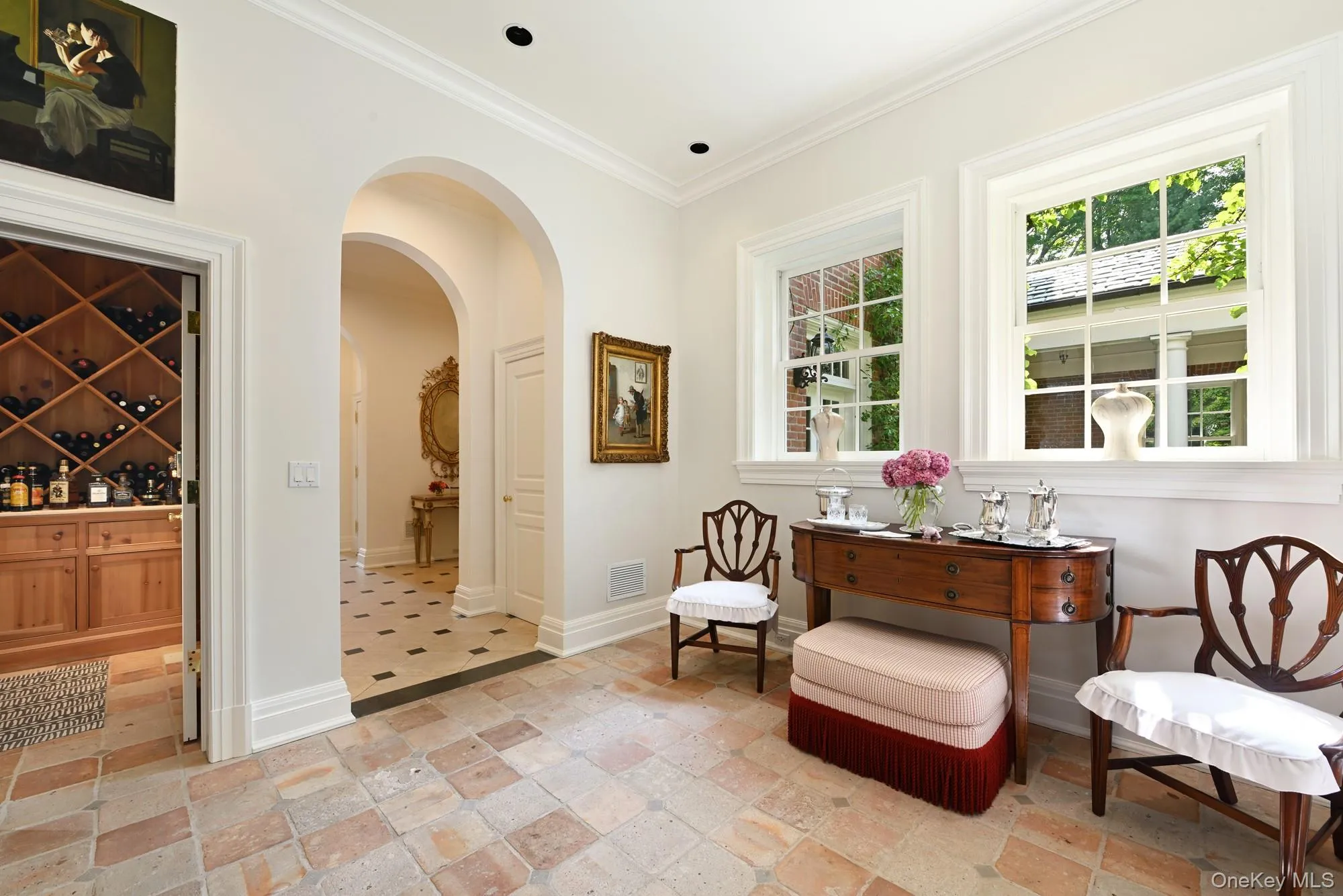 Living area featuring arched walkways, crown molding, and stone tile floors Living area featuring arched walkways, crown molding, and stone tile floors