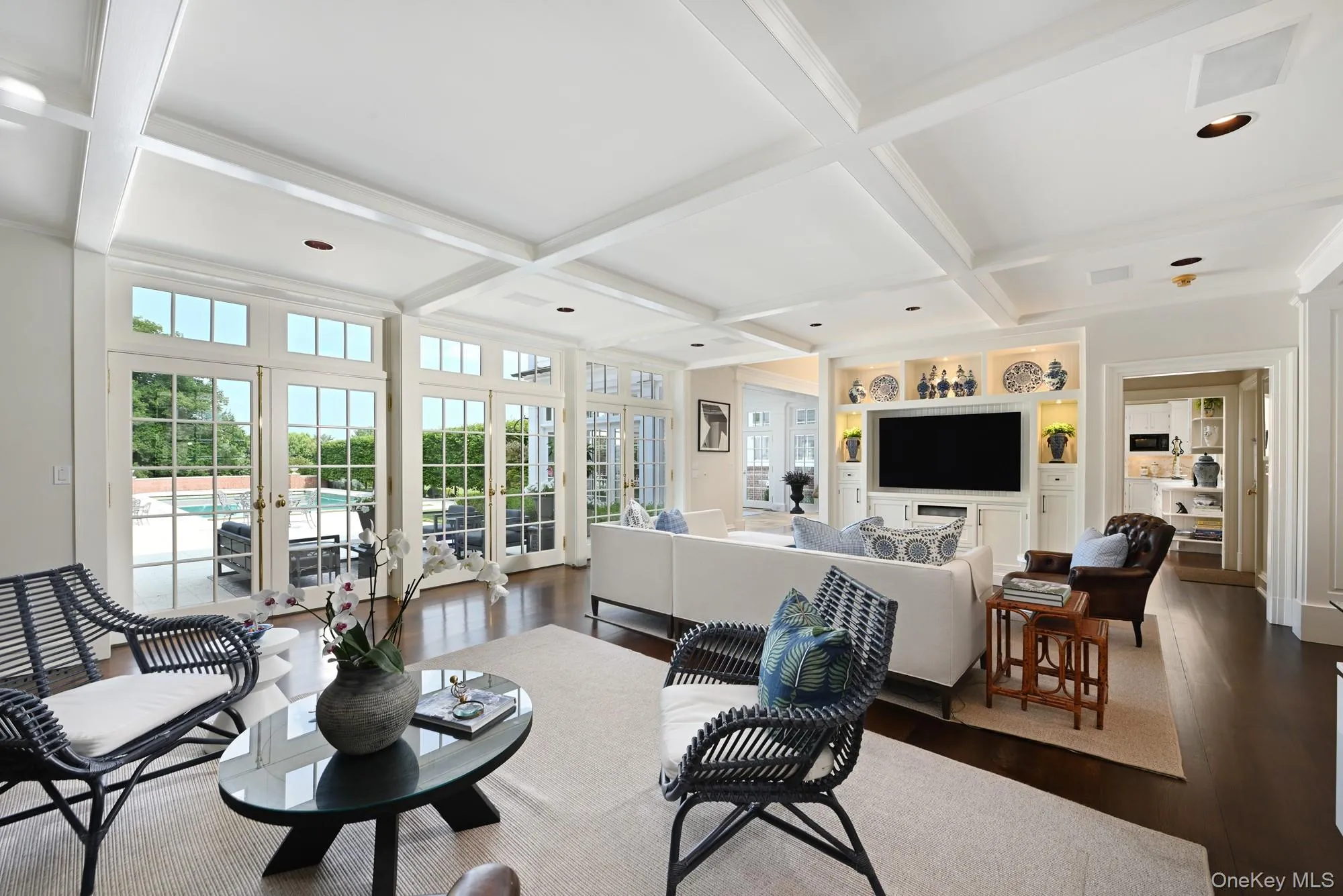 Living room featuring beamed ceiling, coffered ceiling, dark wood-style floors, french doors, and crown molding Living room featuring beamed ceiling, coffered ceiling, dark wood-style floors, french doors, and crown molding