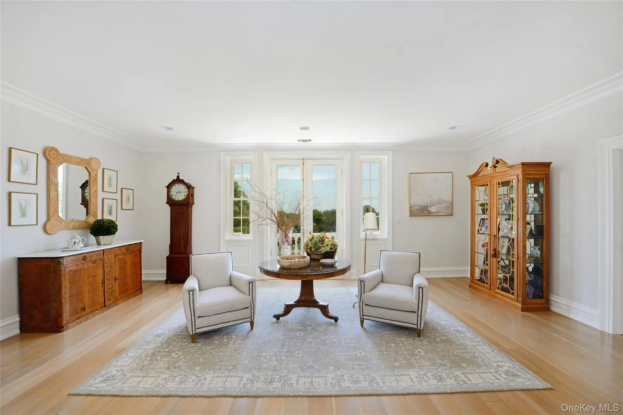 Living area with light wood-style flooring and crown molding Living area with light wood-style flooring and crown molding