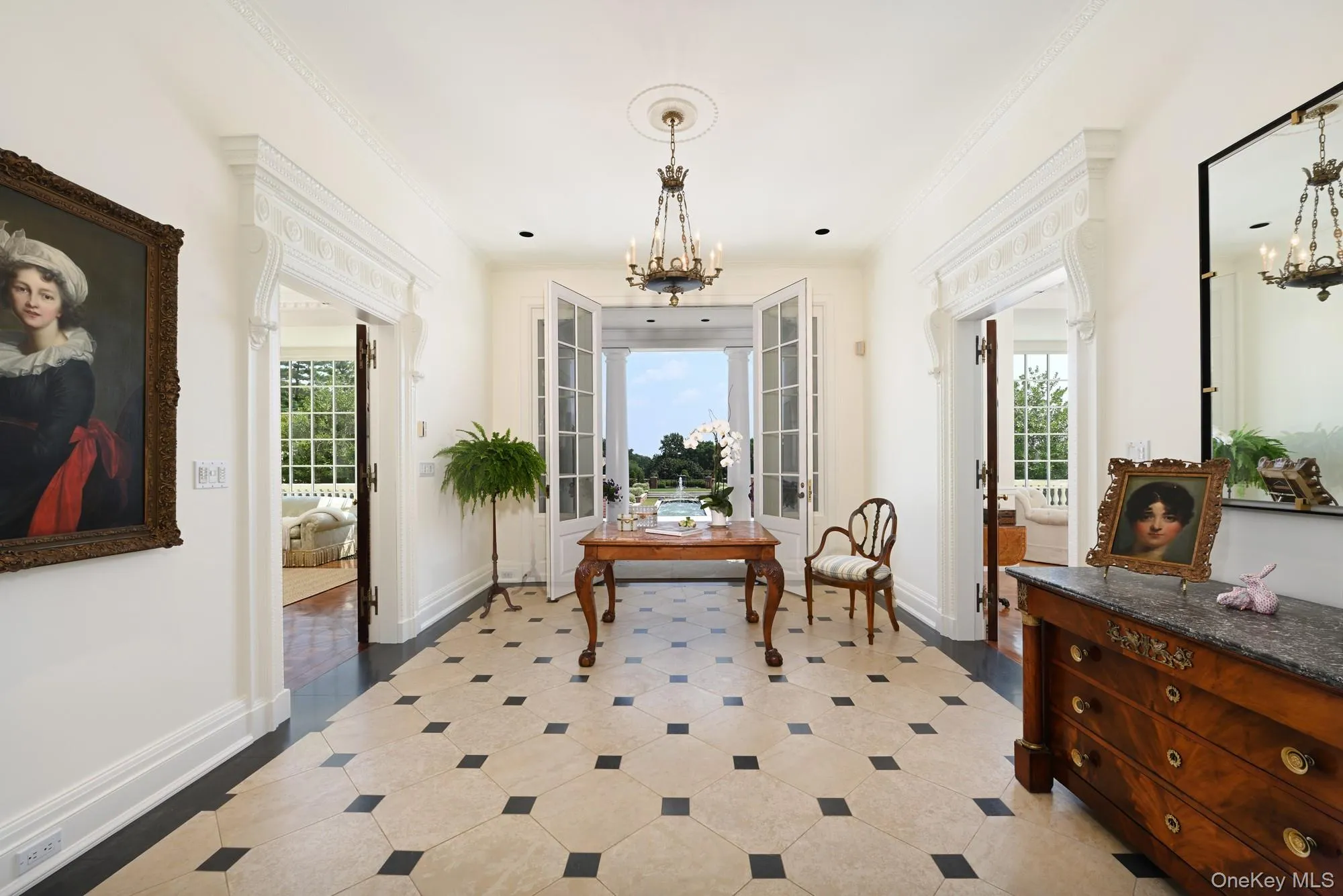 Living area featuring a chandelier, healthy amount of natural light, crown molding, and french doors Living area featuring a chandelier, healthy amount of natural light, crown molding, and french doors