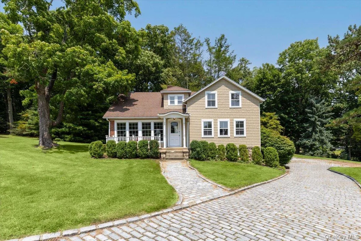 View of front of home with a front yard and view of wooded area View of front of home with a front yard and view of wooded area