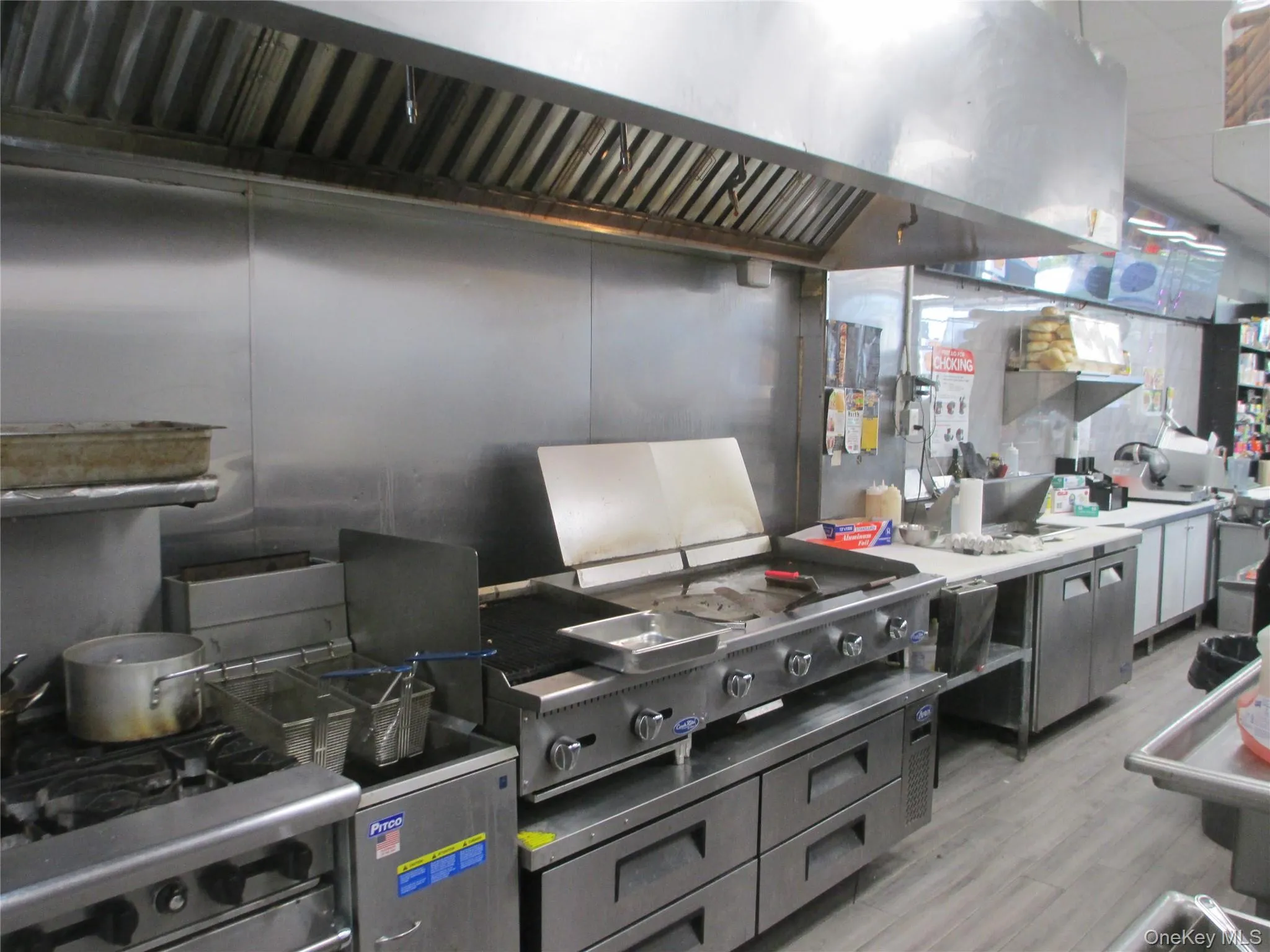 Kitchen featuring extractor fan, stainless steel gas stove, and light wood-style floors Kitchen featuring extractor fan, stainless steel gas stove, and light wood-style floors