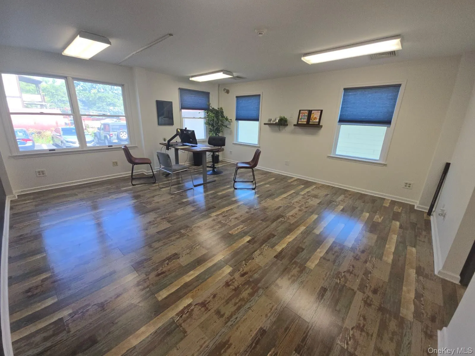 Office space featuring plenty of natural light and dark wood-type flooring Office space featuring plenty of natural light and dark wood-type flooring