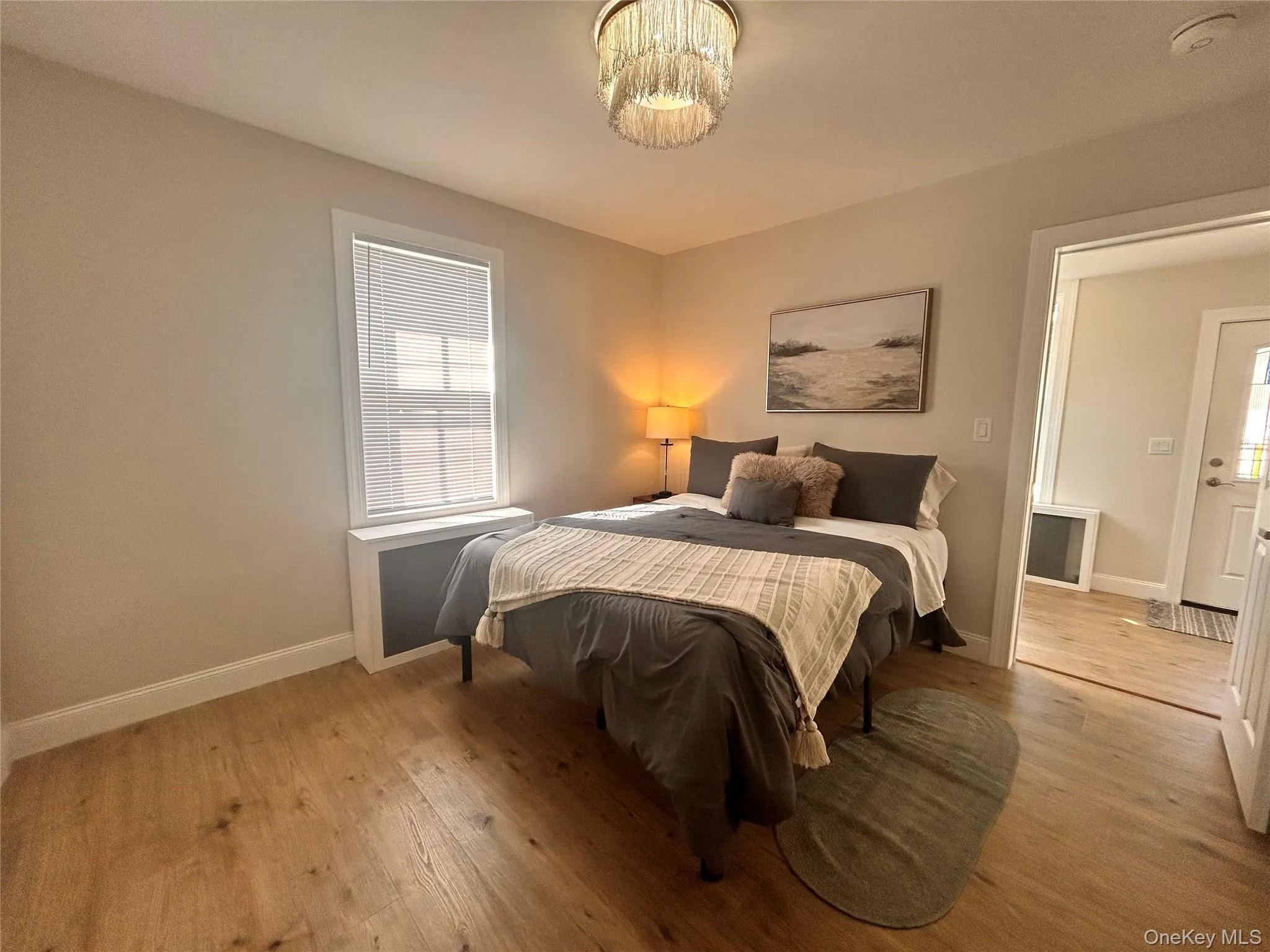 Bedroom with light wood-style floors and multiple windows Bedroom with light wood-style floors and multiple windows
