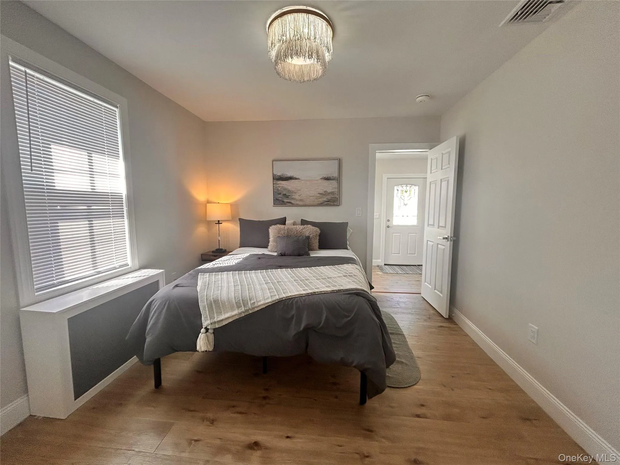 Bedroom featuring radiator and light wood-style floors Bedroom featuring radiator and light wood-style floors
