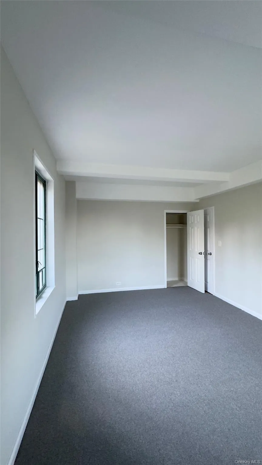 Unfurnished room with baseboards and dark colored carpet Unfurnished room with baseboards and dark colored carpet