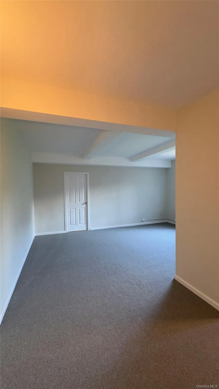 Unfurnished room with dark carpet and beam ceiling Unfurnished room with dark carpet and beam ceiling
