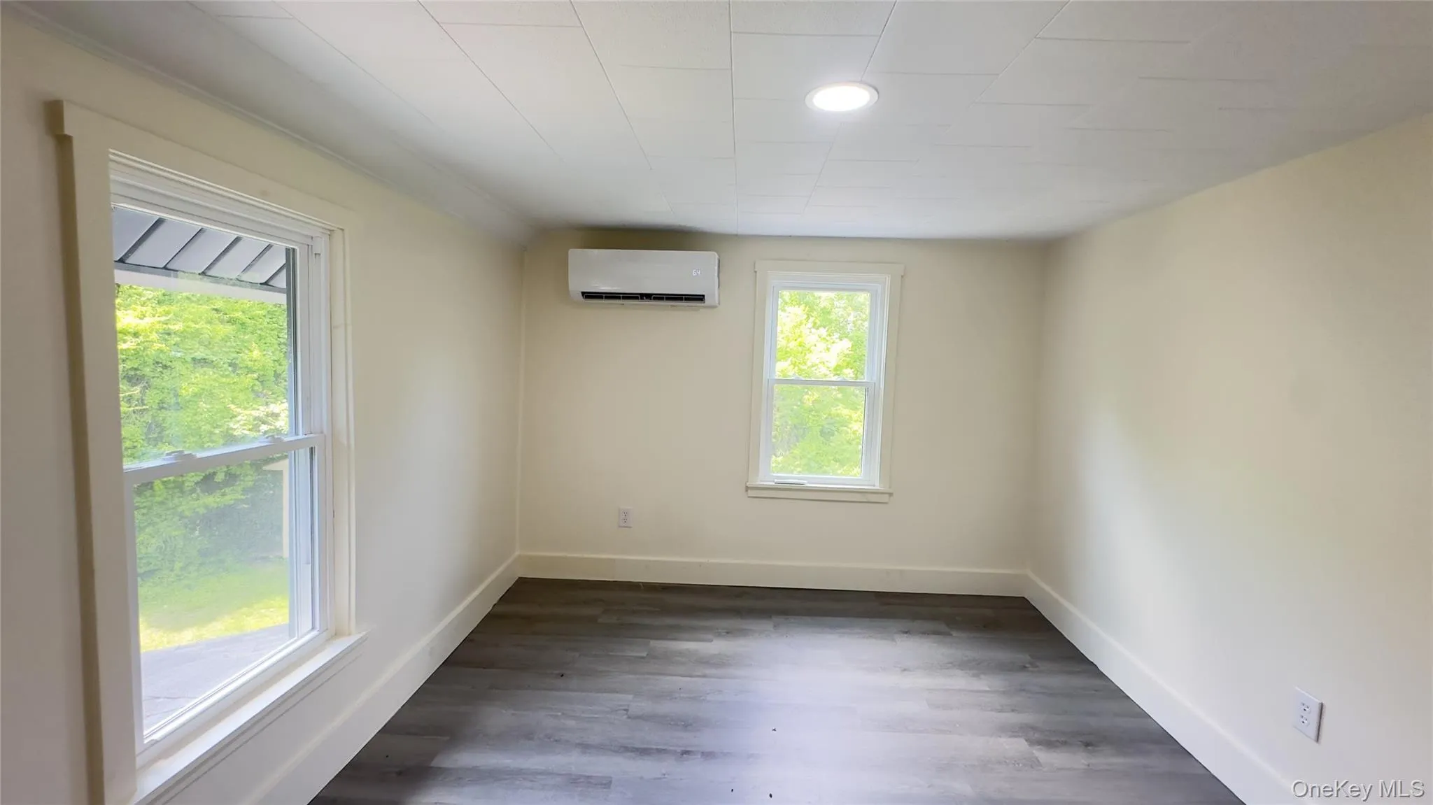 Unfurnished room featuring a wall unit AC and vinyl flooring Unfurnished room featuring a wall unit AC and vinyl flooring