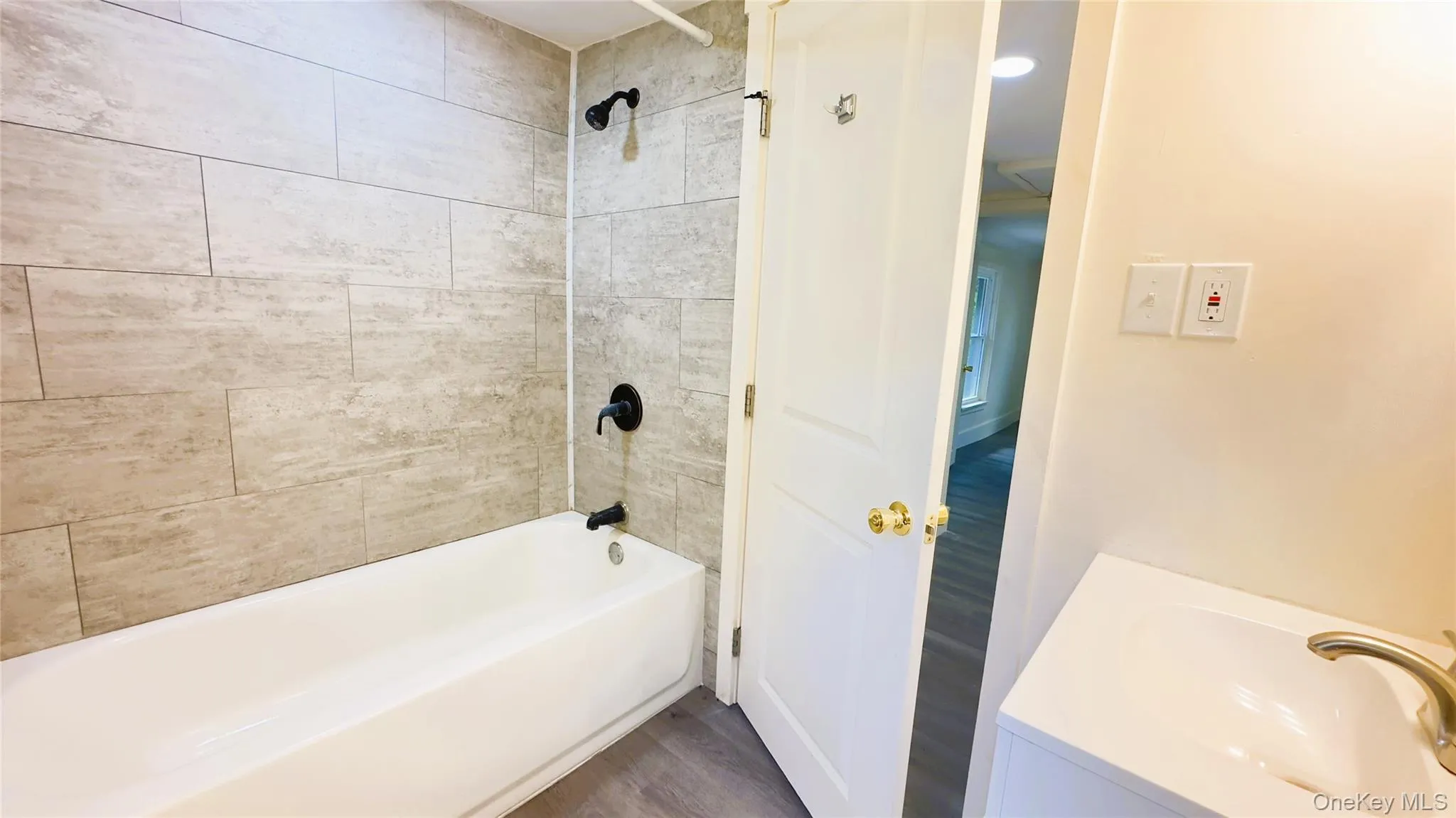 Bathroom featuring tub / shower combination, vanity, and vinyl  floors Bathroom featuring tub / shower combination, vanity, and vinyl  floors