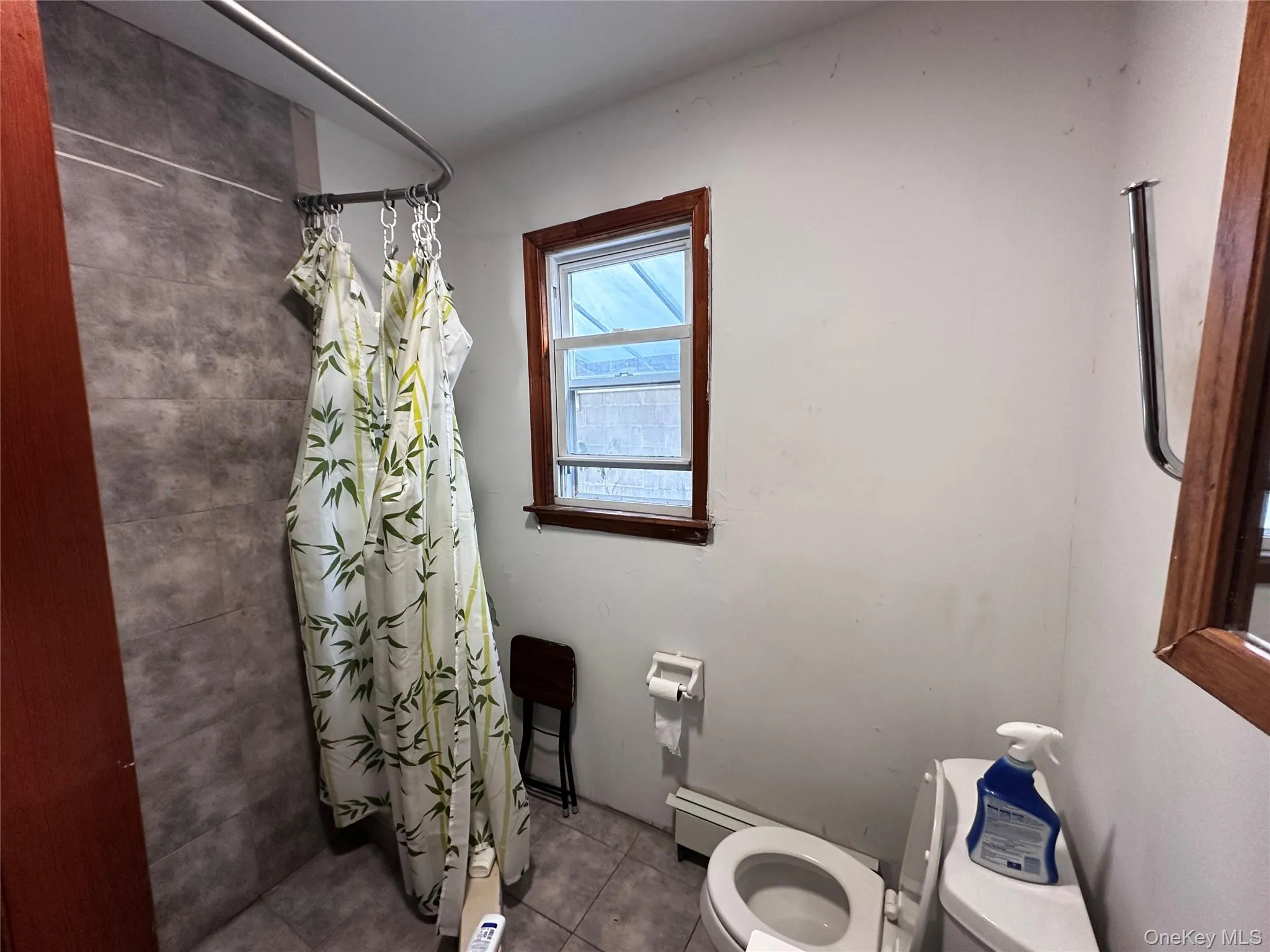 Bathroom featuring curtained shower and tile patterned flooring Bathroom featuring curtained shower and tile patterned flooring
