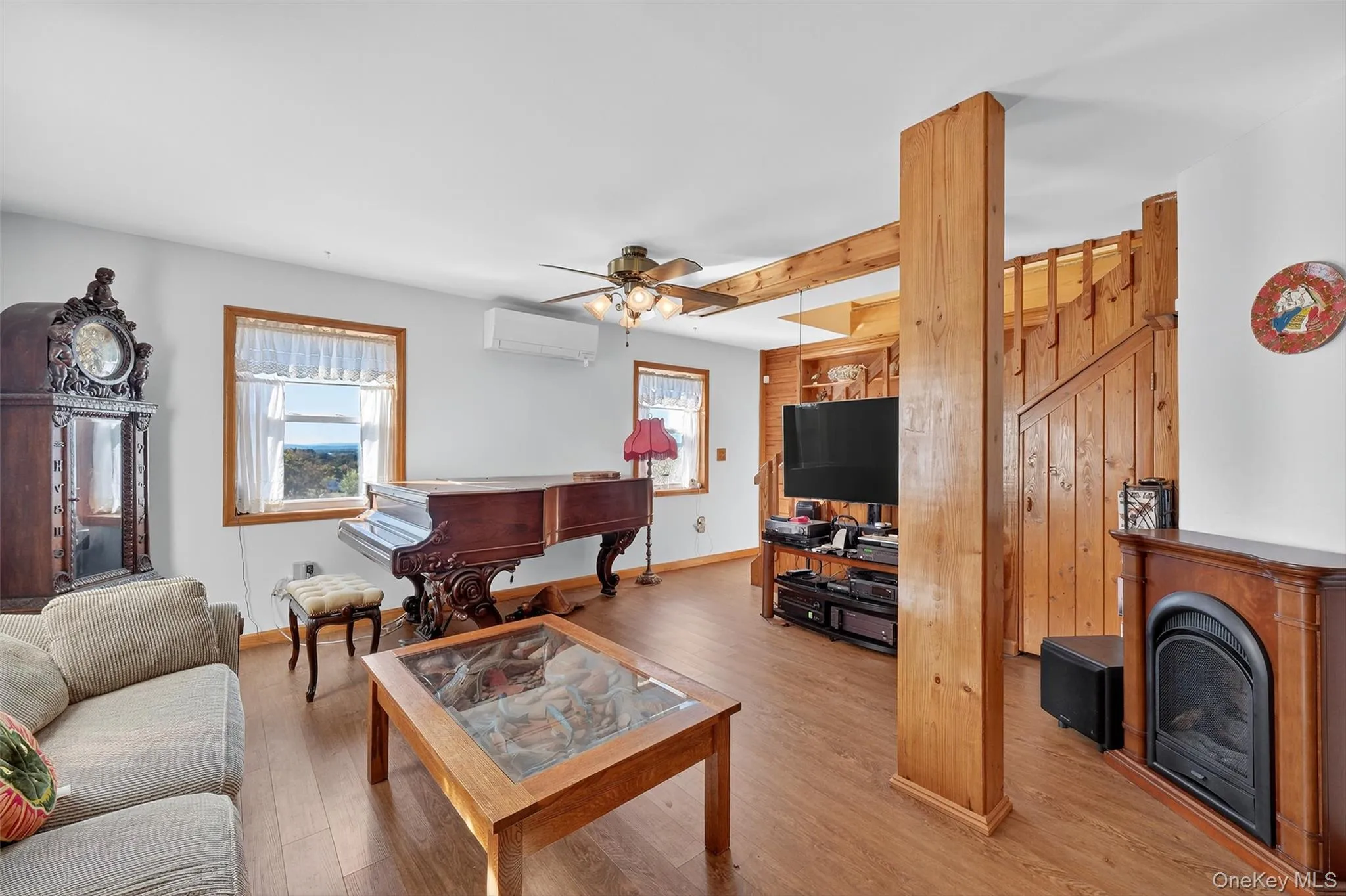 Living room with wood finished floors, a ceiling fan and AC Living room with wood finished floors, a ceiling fan and AC
