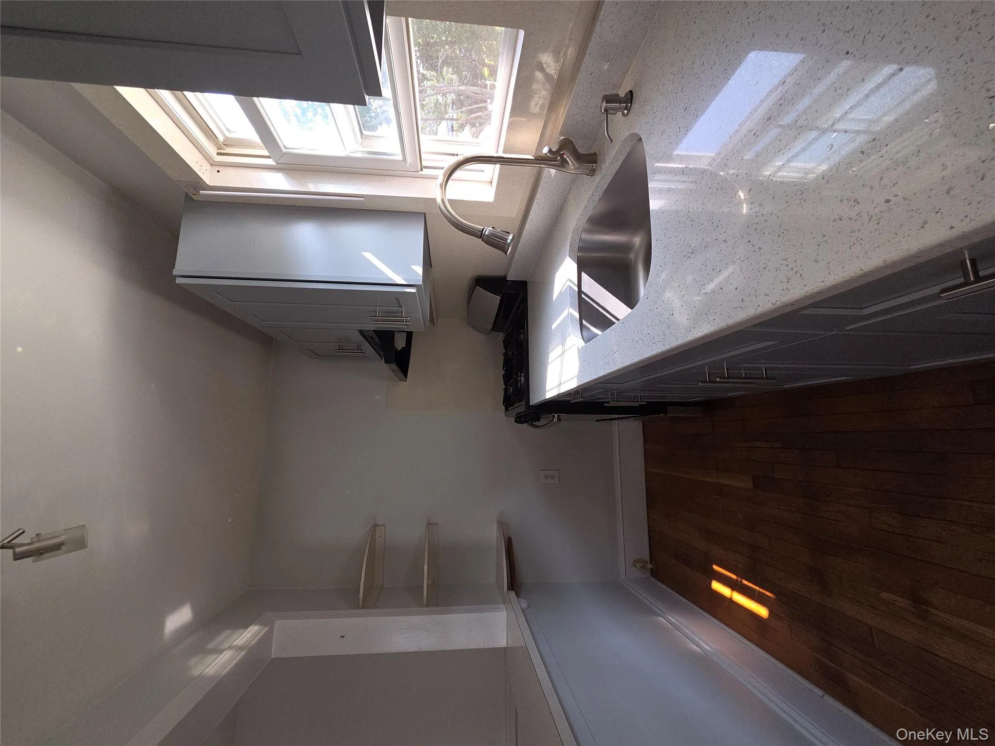 Kitchen with gray cabinets, stove, light stone countertops, dark wood finished floors, and open shelves Kitchen with gray cabinets, stove, light stone countertops, dark wood finished floors, and open shelves