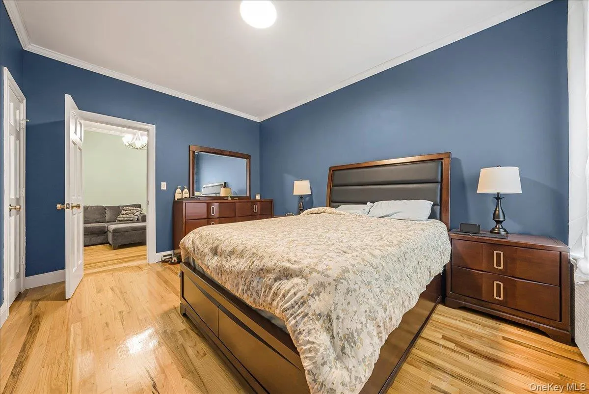 Bedroom with crown molding and light wood-style flooring Bedroom with crown molding and light wood-style flooring