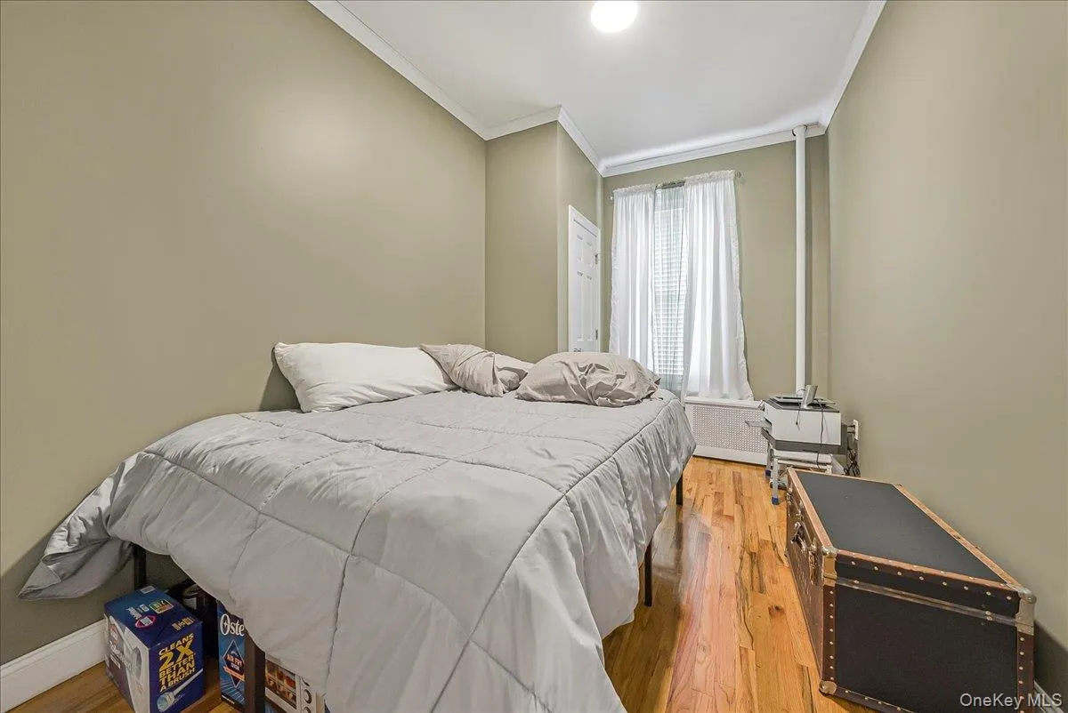 Bedroom with light wood-style floors and ornamental molding Bedroom with light wood-style floors and ornamental molding