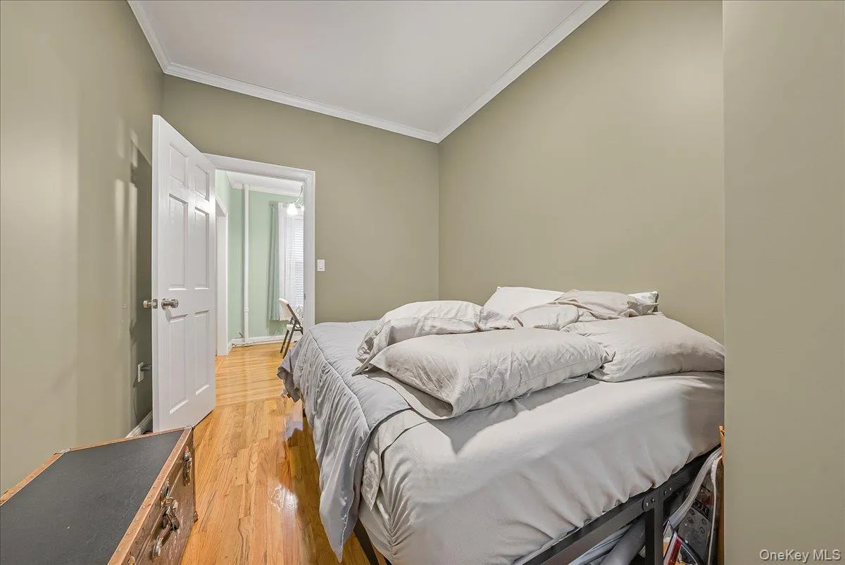 Bedroom featuring light wood finished floors and crown molding Bedroom featuring light wood finished floors and crown molding