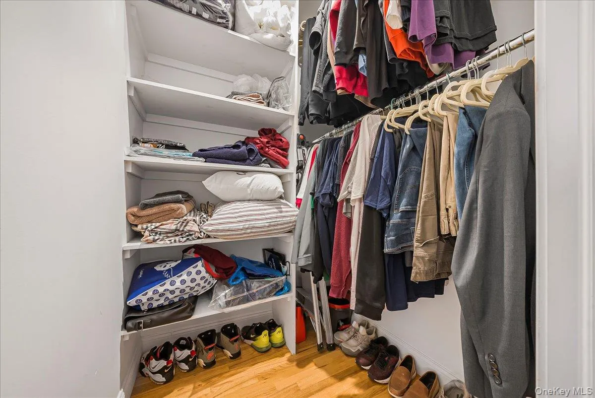 Spacious closet with light wood-style flooring Spacious closet with light wood-style flooring