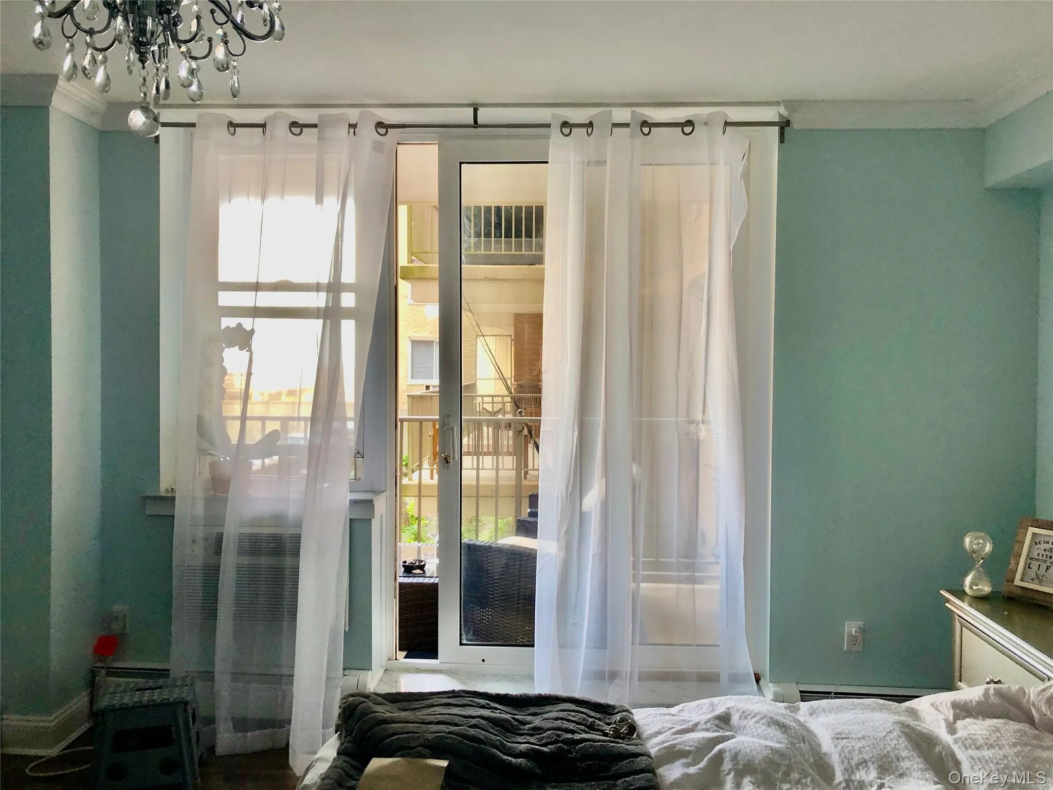 Bedroom with multiple windows, ornamental molding, and a chandelier Bedroom with multiple windows, ornamental molding, and a chandelier