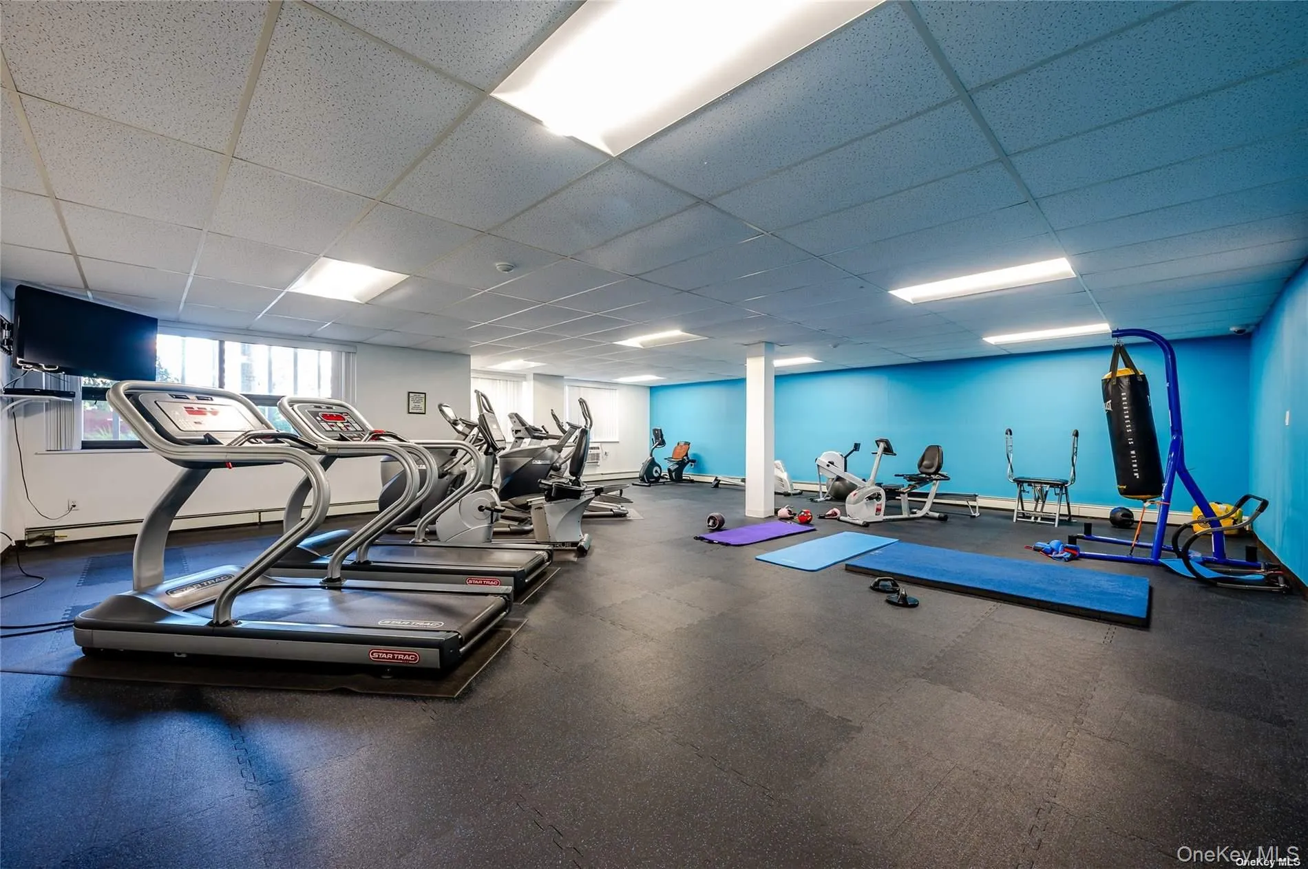 Exercise room with a paneled ceiling and a baseboard radiator Exercise room with a paneled ceiling and a baseboard radiator