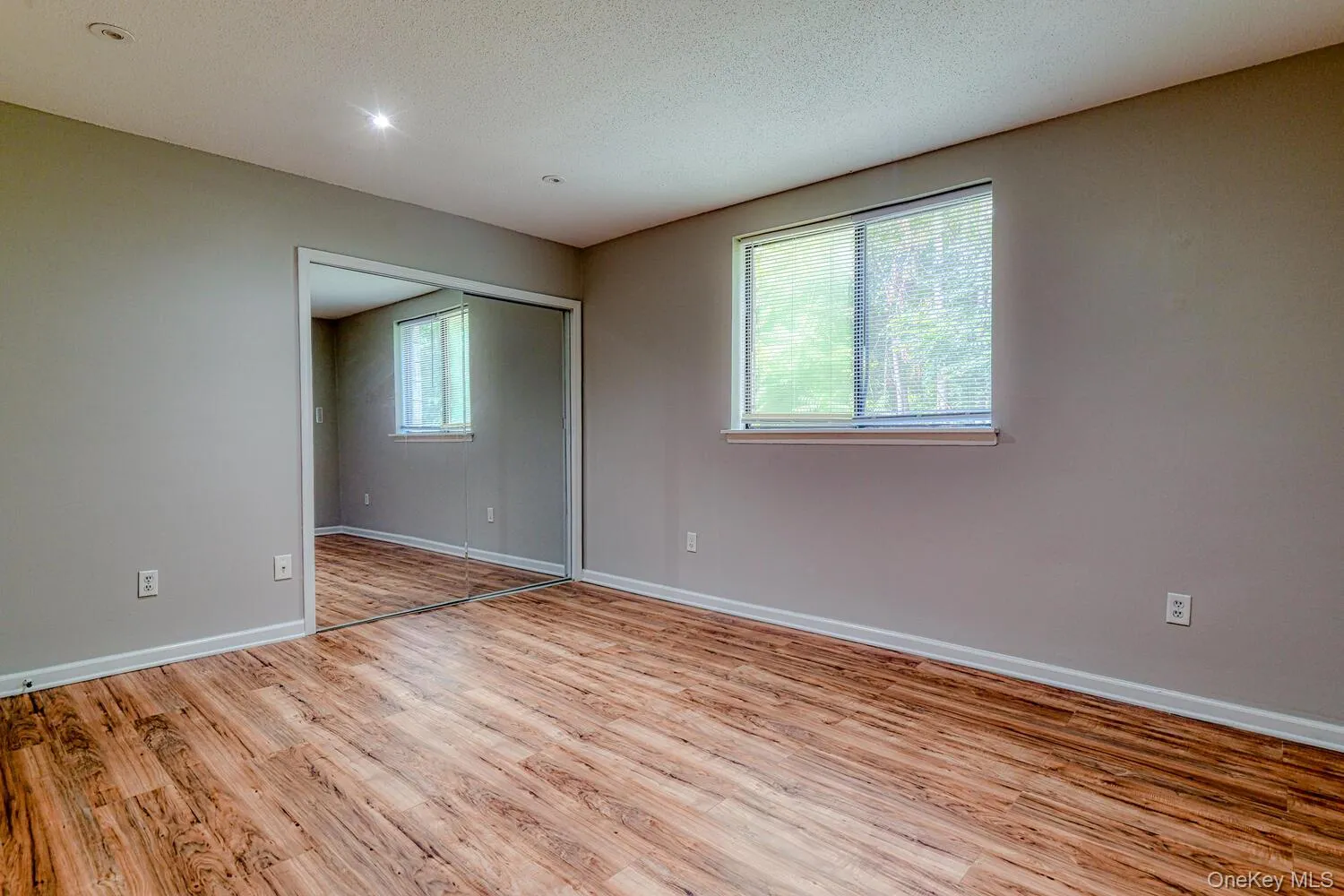Spare room with light wood-style flooring and a textured ceiling Spare room with light wood-style flooring and a textured ceiling