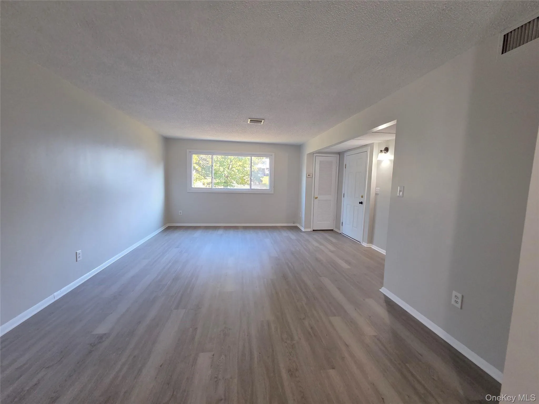 Spare room featuring dark wood-style floors and a textured ceiling Spare room featuring dark wood-style floors and a textured ceiling