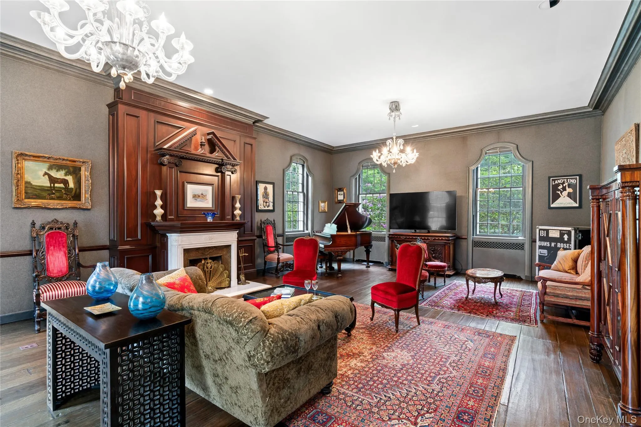 Living room with a chandelier, ornamental molding, a fireplace, and dark wood finished floors Living room with a chandelier, ornamental molding, a fireplace, and dark wood finished floors