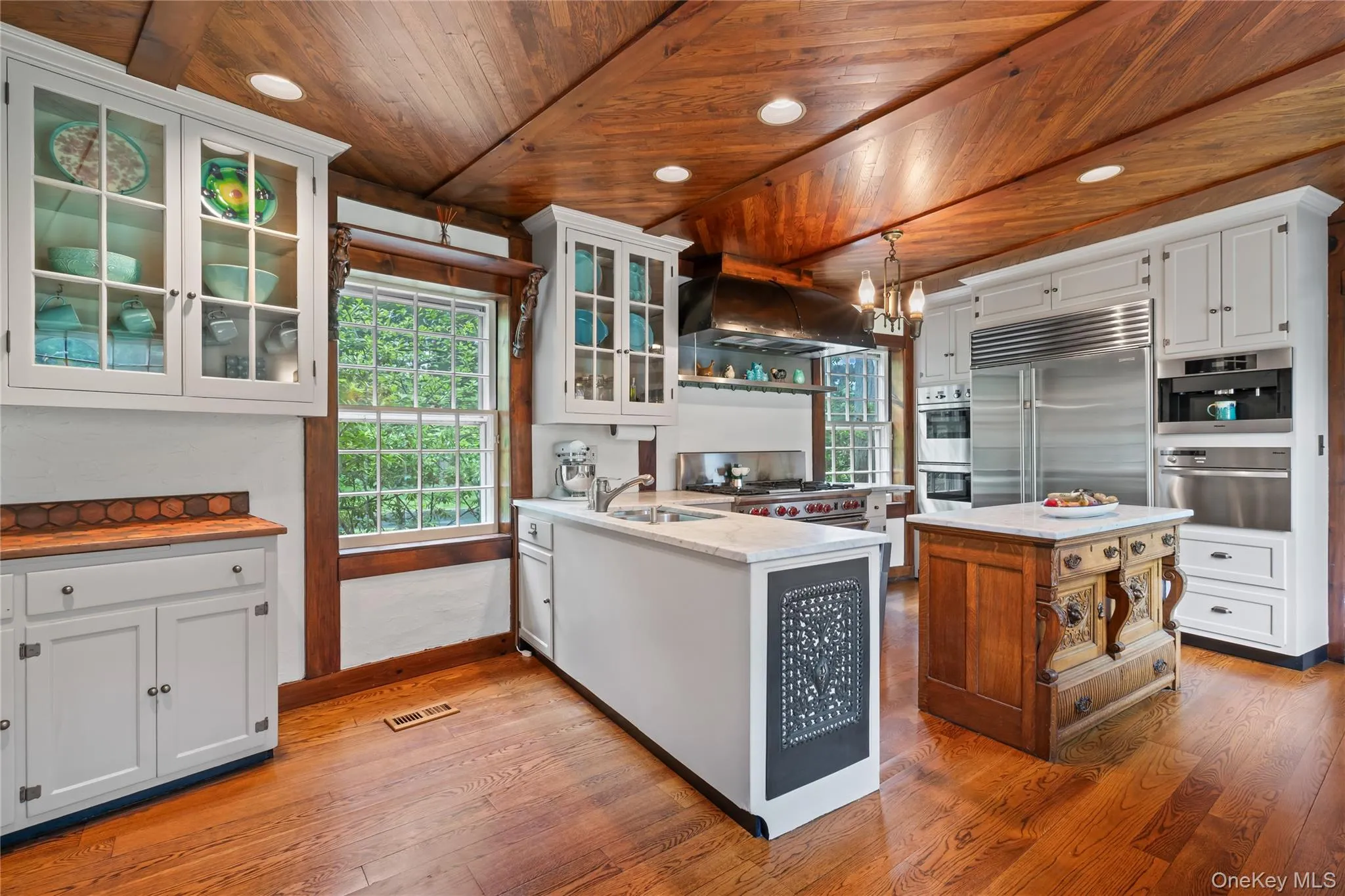 Kitchen featuring a peninsula, plenty of natural light, white cabinetry, recessed lighting, and a wooden ceiling with exposed beams Kitchen featuring a peninsula, plenty of natural light, white cabinetry, recessed lighting, and a wooden ceiling with exposed beams