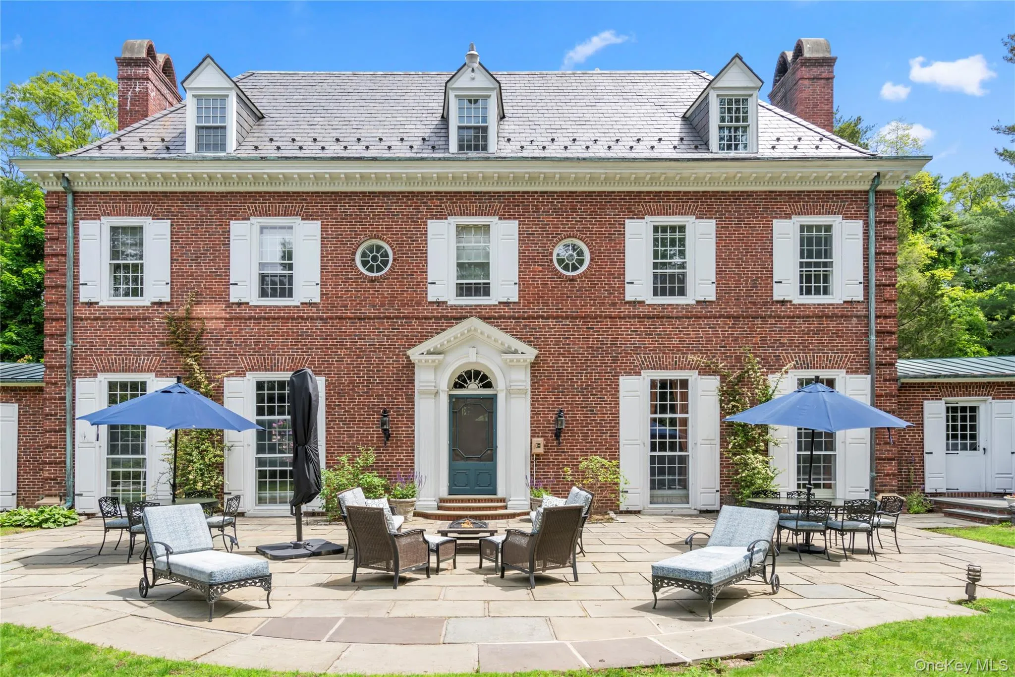 Back of property featuring a patio, a high end roof, and a chimney Back of property featuring a patio, a high end roof, and a chimney