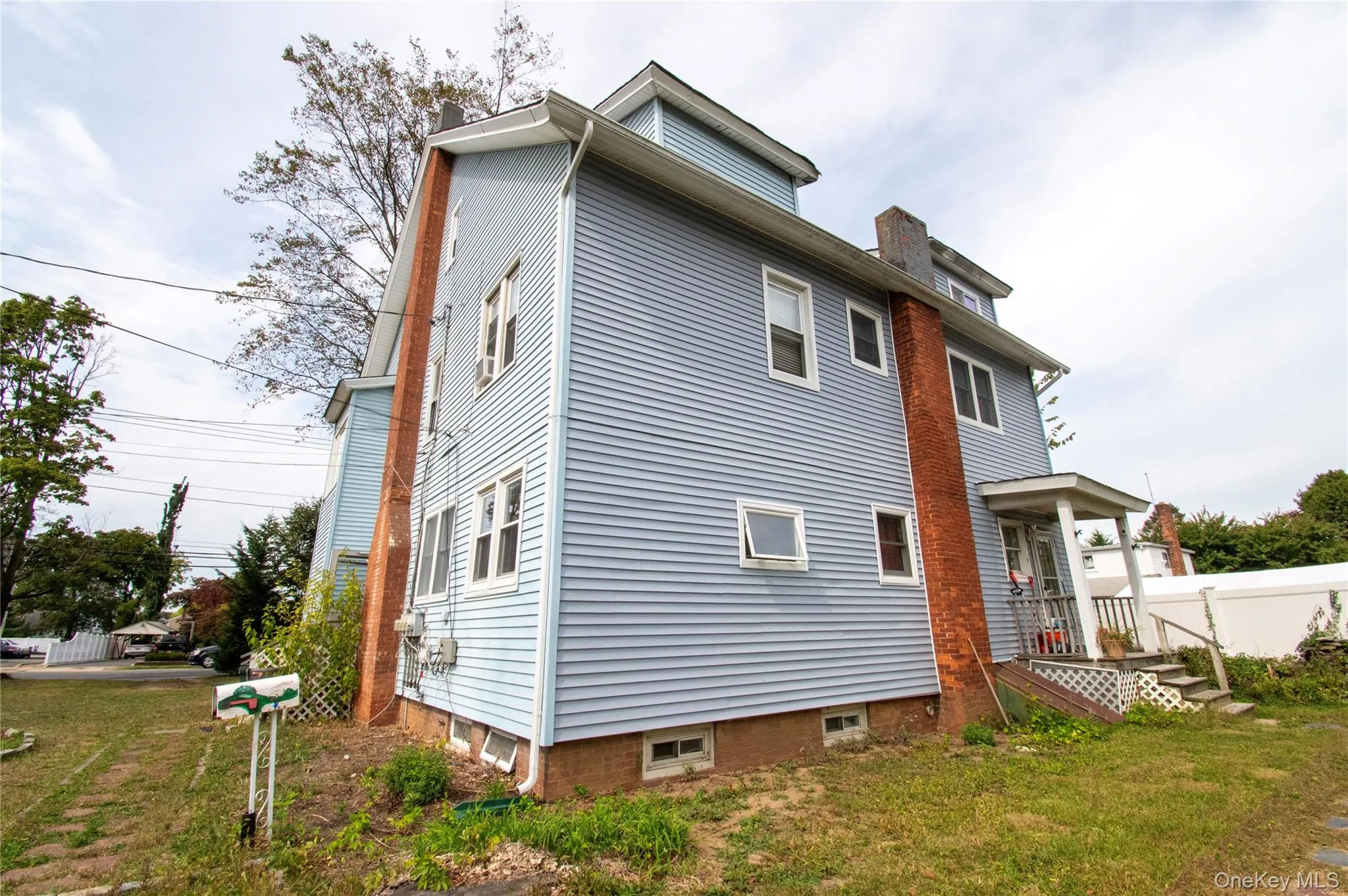 Rear view of property featuring a chimney and a lawn Rear view of property featuring a chimney and a lawn
