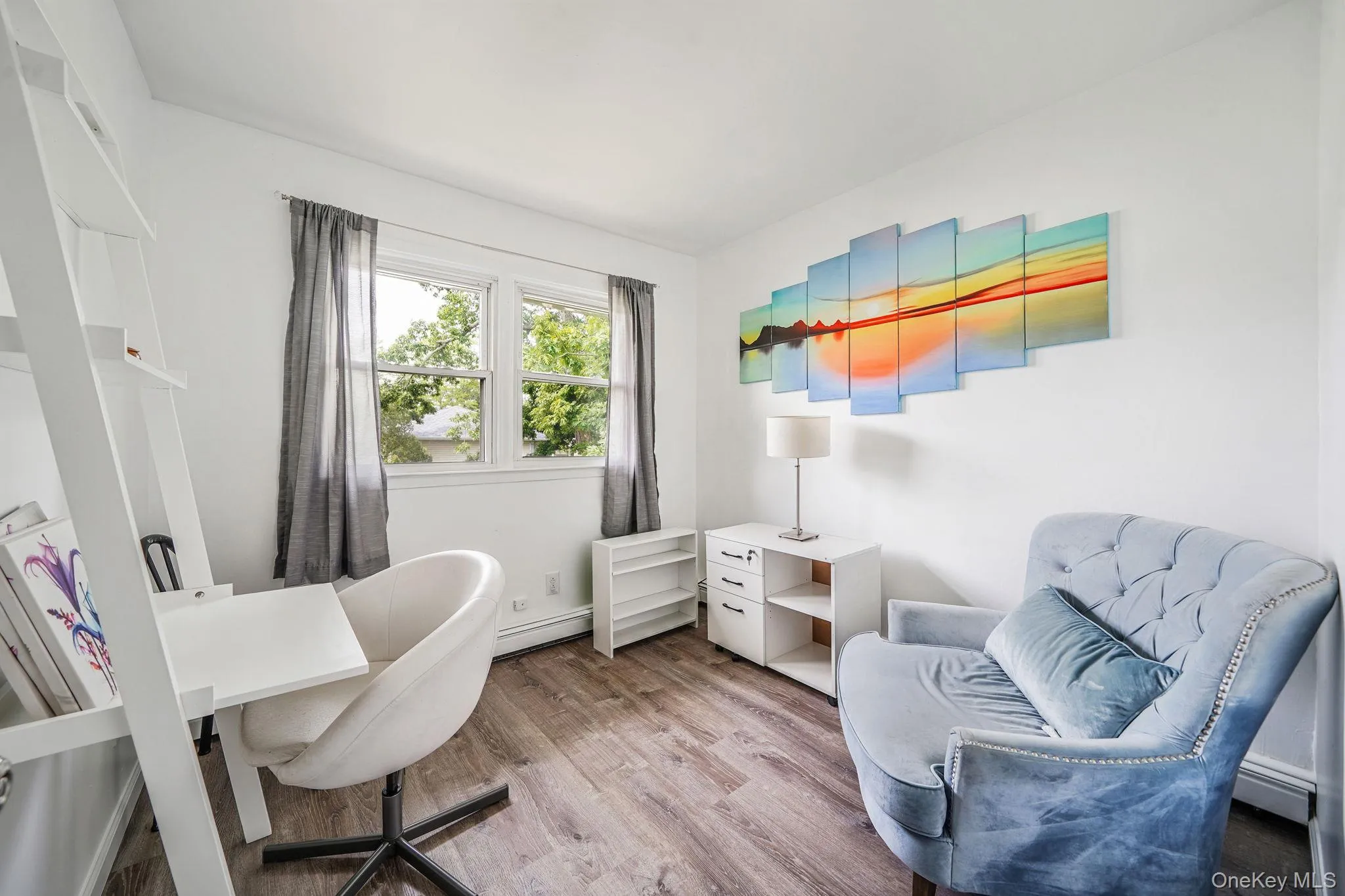 Home office featuring light wood-style floors and a baseboard heating unit Home office featuring light wood-style floors and a baseboard heating unit