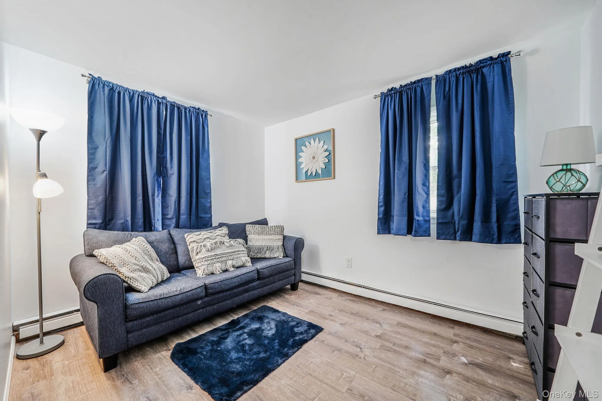 Living area with baseboard heating and light wood-type flooring Living area with baseboard heating and light wood-type flooring