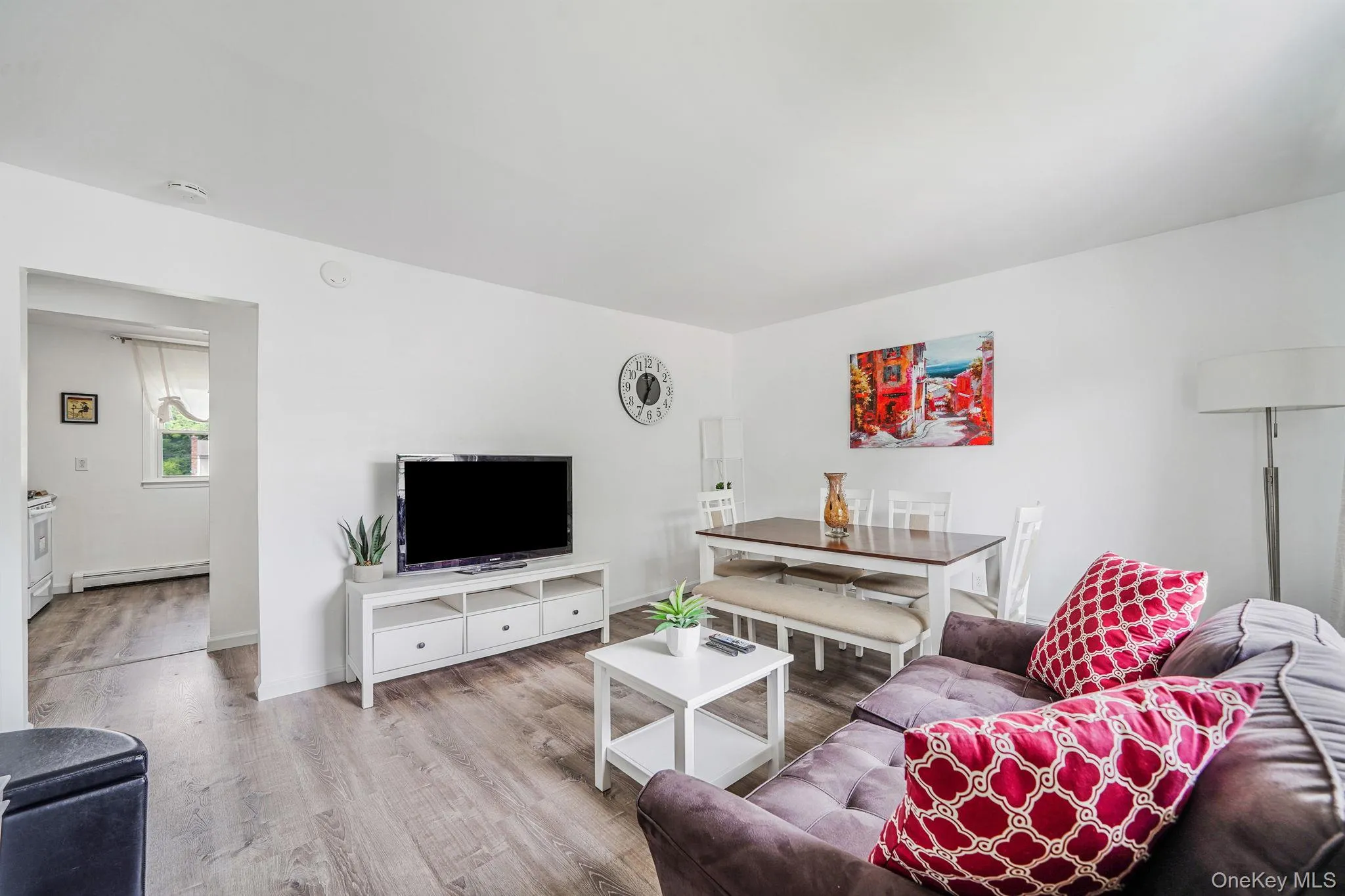 Living room featuring wood finished floors and a baseboard radiator Living room featuring wood finished floors and a baseboard radiator