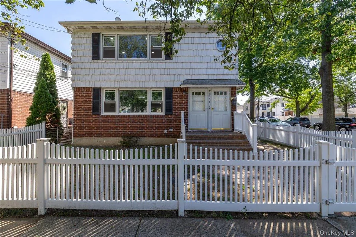 View of front facade featuring a fenced front yard, brick siding, and a gate View of front facade featuring a fenced front yard, brick siding, and a gate
