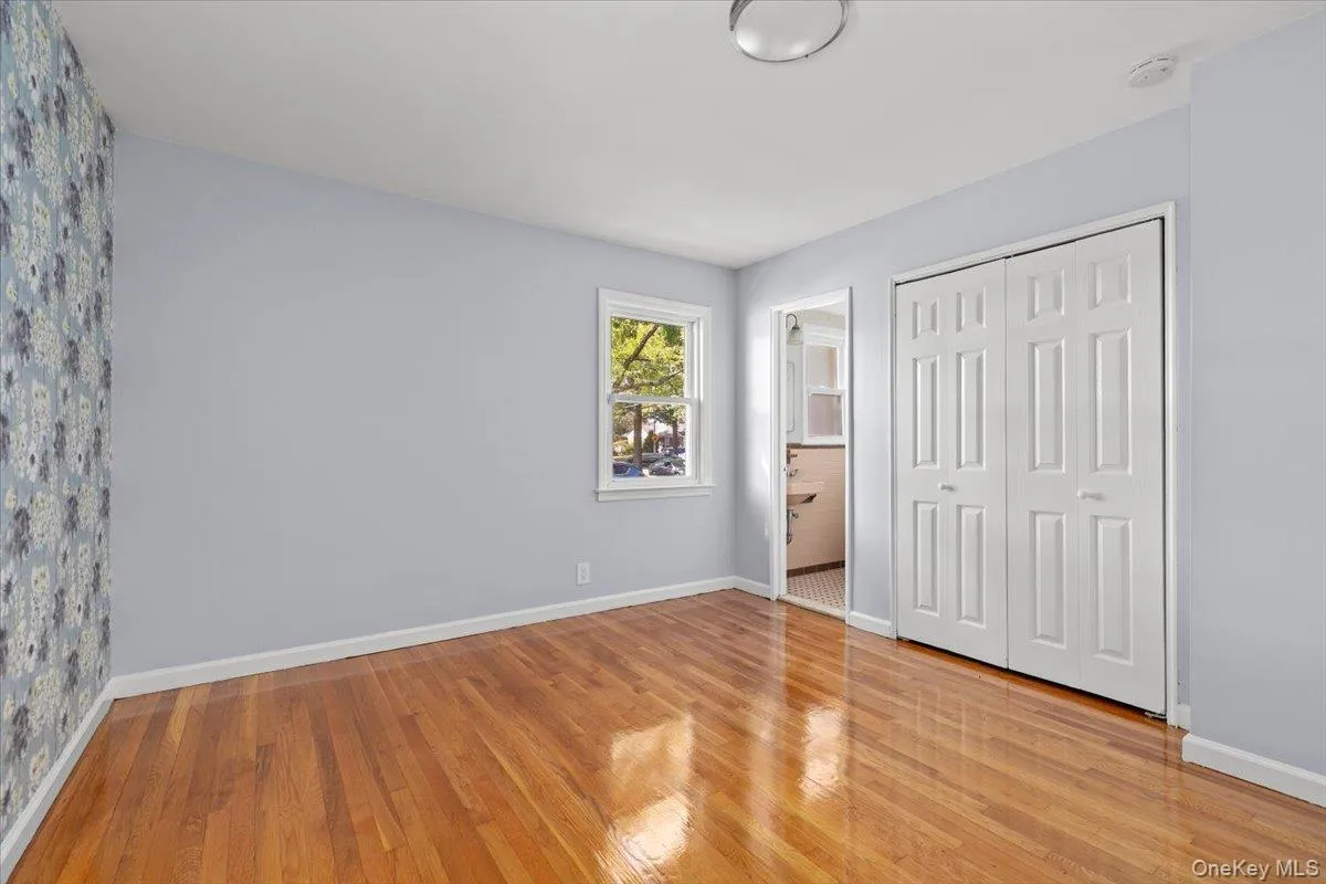 Unfurnished bedroom with light wood-style floors, a closet, and ensuite bathroom Unfurnished bedroom with light wood-style floors, a closet, and ensuite bathroom
