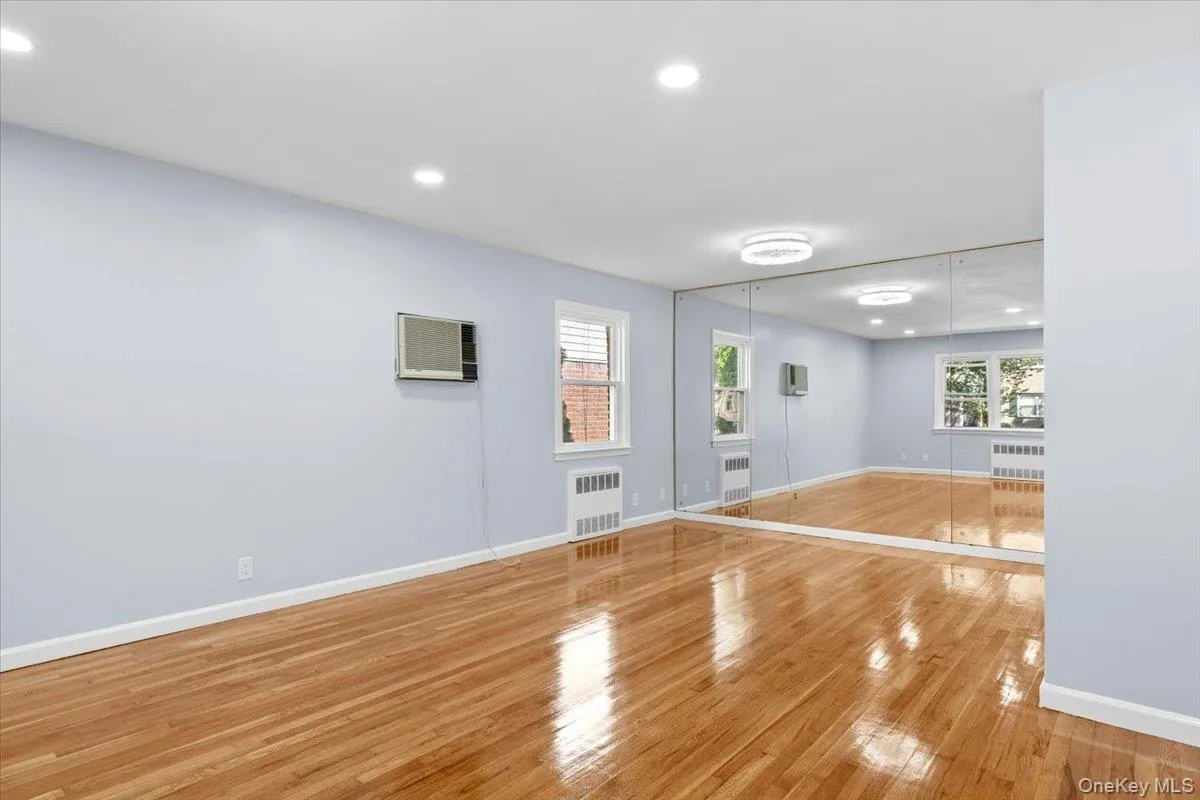 Spare room featuring light wood-style floors, recessed lighting, healthy amount of natural light, and radiator Spare room featuring light wood-style floors, recessed lighting, healthy amount of natural light, and radiator