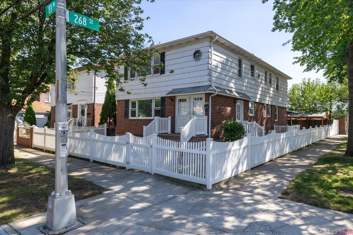 Colonial inspired home featuring brick siding and a fenced front yard Colonial inspired home featuring brick siding and a fenced front yard