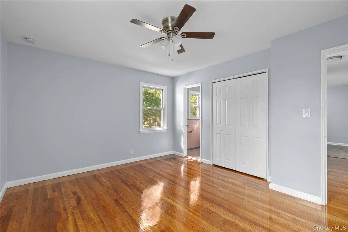 Unfurnished bedroom with light wood-style floors, a ceiling fan, and a closet Unfurnished bedroom with light wood-style floors, a ceiling fan, and a closet