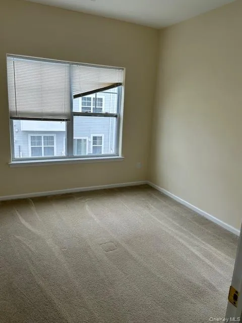 Carpeted spare room featuring baseboards Carpeted spare room featuring baseboards