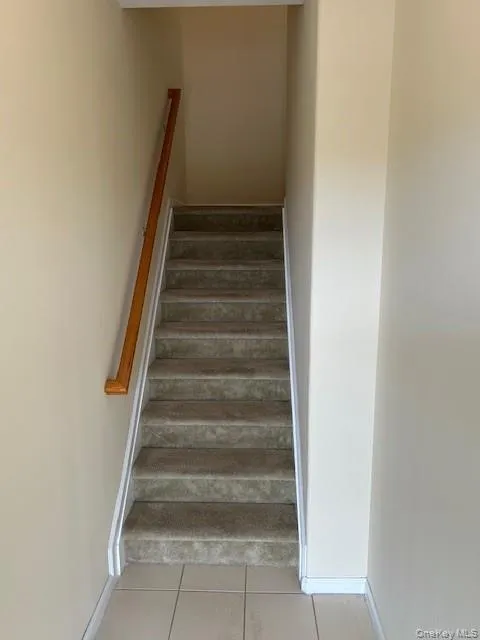 Stairway featuring tile patterned floors and baseboards Stairway featuring tile patterned floors and baseboards