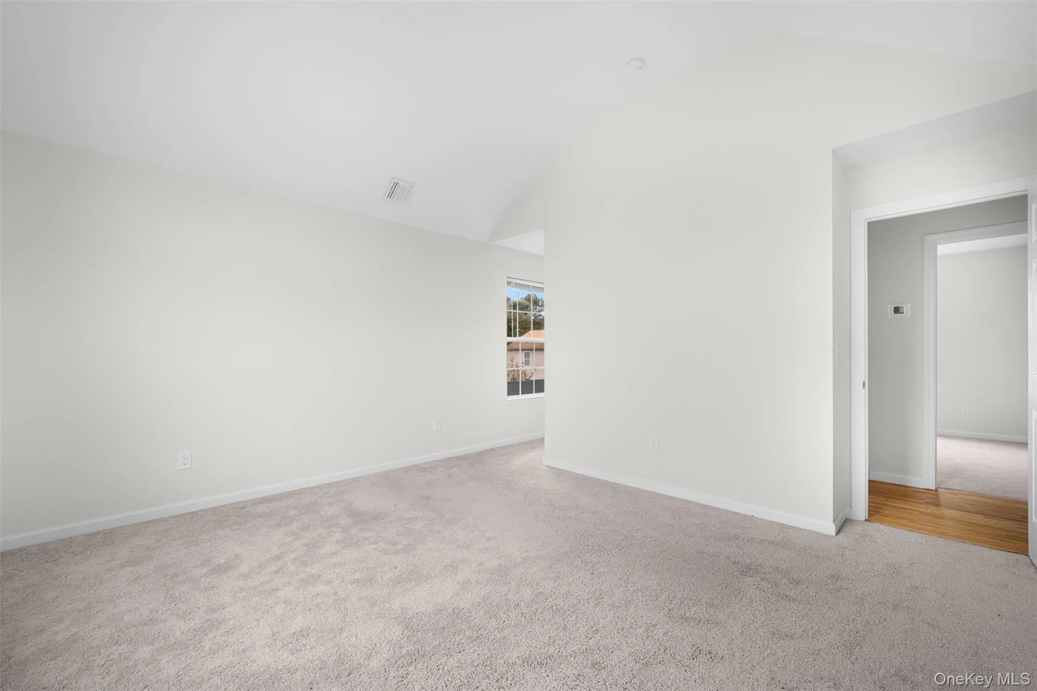 Empty room featuring lofted ceiling and carpet Empty room featuring lofted ceiling and carpet